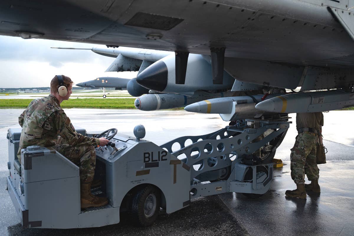 Air Force personnel load DATM-160s onto an A-10C Warthog at Andersen Air Force Base on November 4. A B-1B bomber is seen in the background. <em>USAF</em>