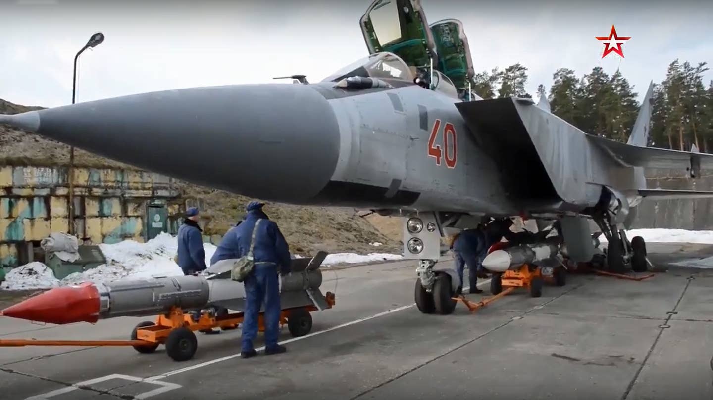 R-33 air-to-air missiles are loaded onto a MiG-31BM at Khotilovo Air Base in a capture from an official Russian Ministry of Defense video in 2020. <em>Zvezda TV</em>