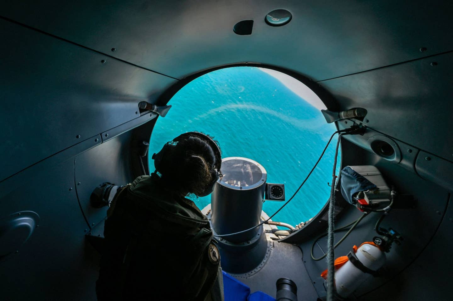 A crew member watches from onboard an Atlantique 2 as it flies over the Black Sea on July 21, 2022. The ‘Mark One Eyeball’ remains a vital surveillance tool and the glass nose affords an excellent view. <em>Photo by LOUISA GOULIAMAKI/AFP via Getty Images</em>