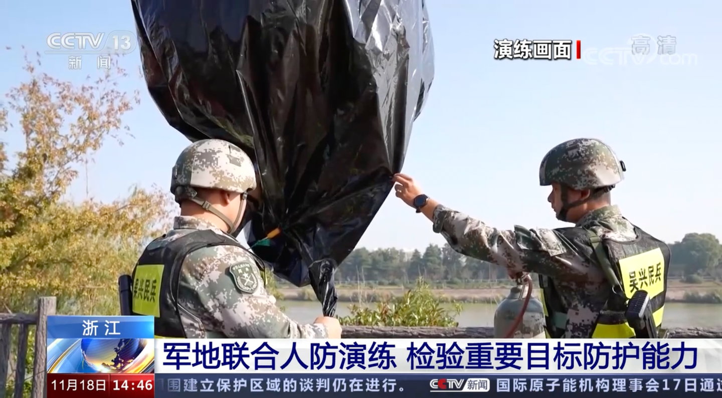 A screenshot from the CCTV broadcast of the drills showing local militants filling one of the barrage balloons. (CCTV screengrab)