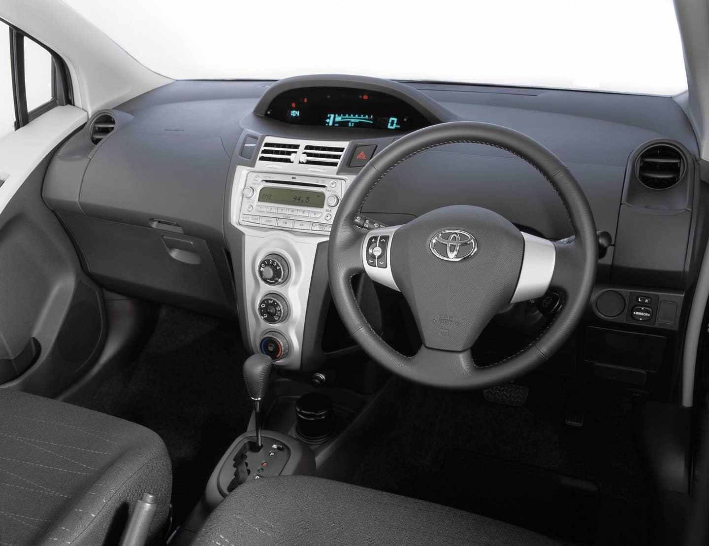 The 2007 Toyota Yaris interior is spartan, but with plenty of storage. Notably, on lower trims, the driver gets a vanity mirror, and the passenger does not. <em>Toyota</em>