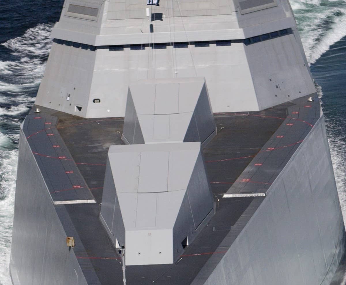 <em>Zumwalt</em>'s twin AGS guns in their stealthy cupolas. These weapons, which take up many decks below their deck mounts, will be ripped out and hypersonic missiles will take their place. (USN via Seaforces.org)