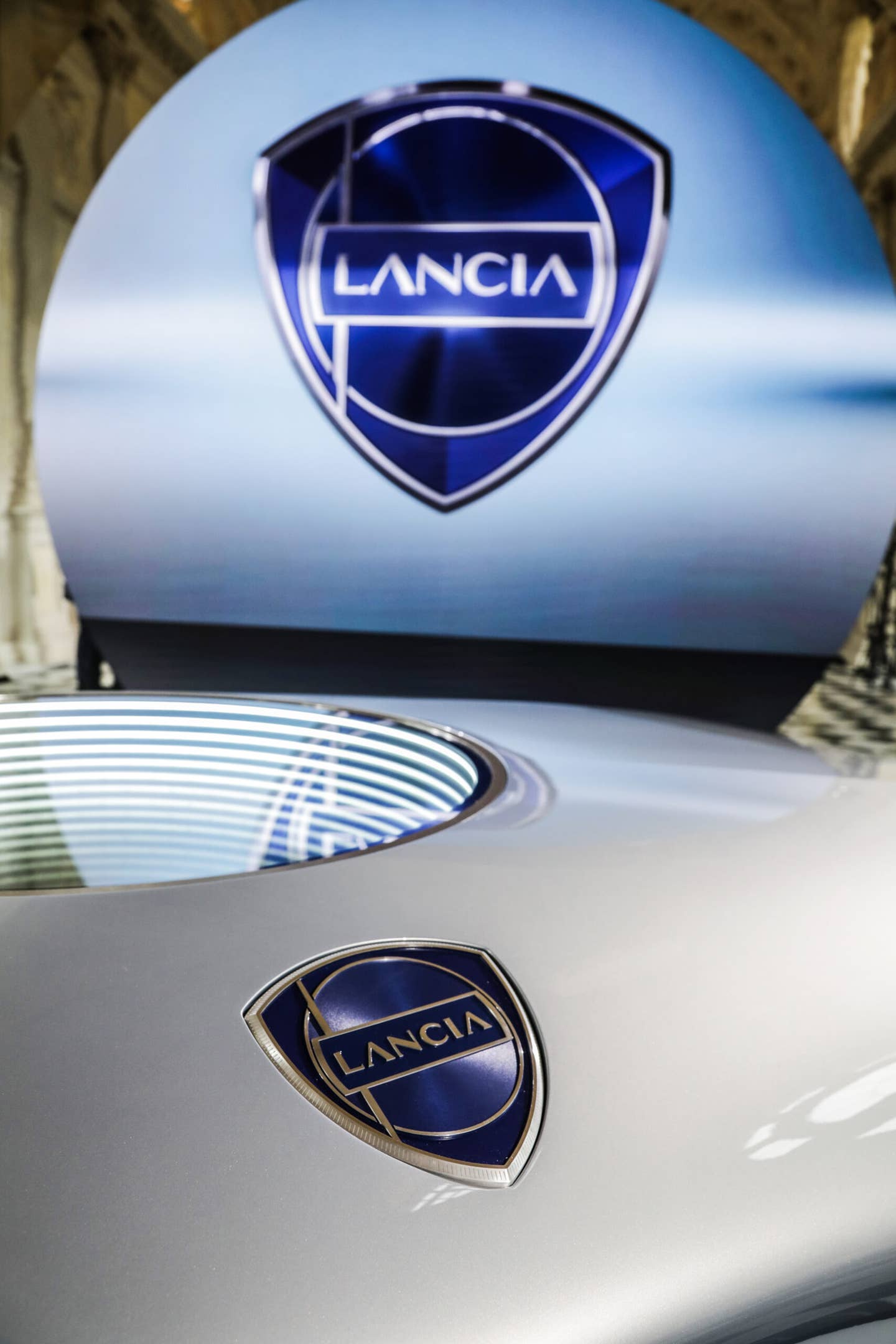 The logo features a lance, because that's what Lancia means in Italian. <em>Lancia</em>