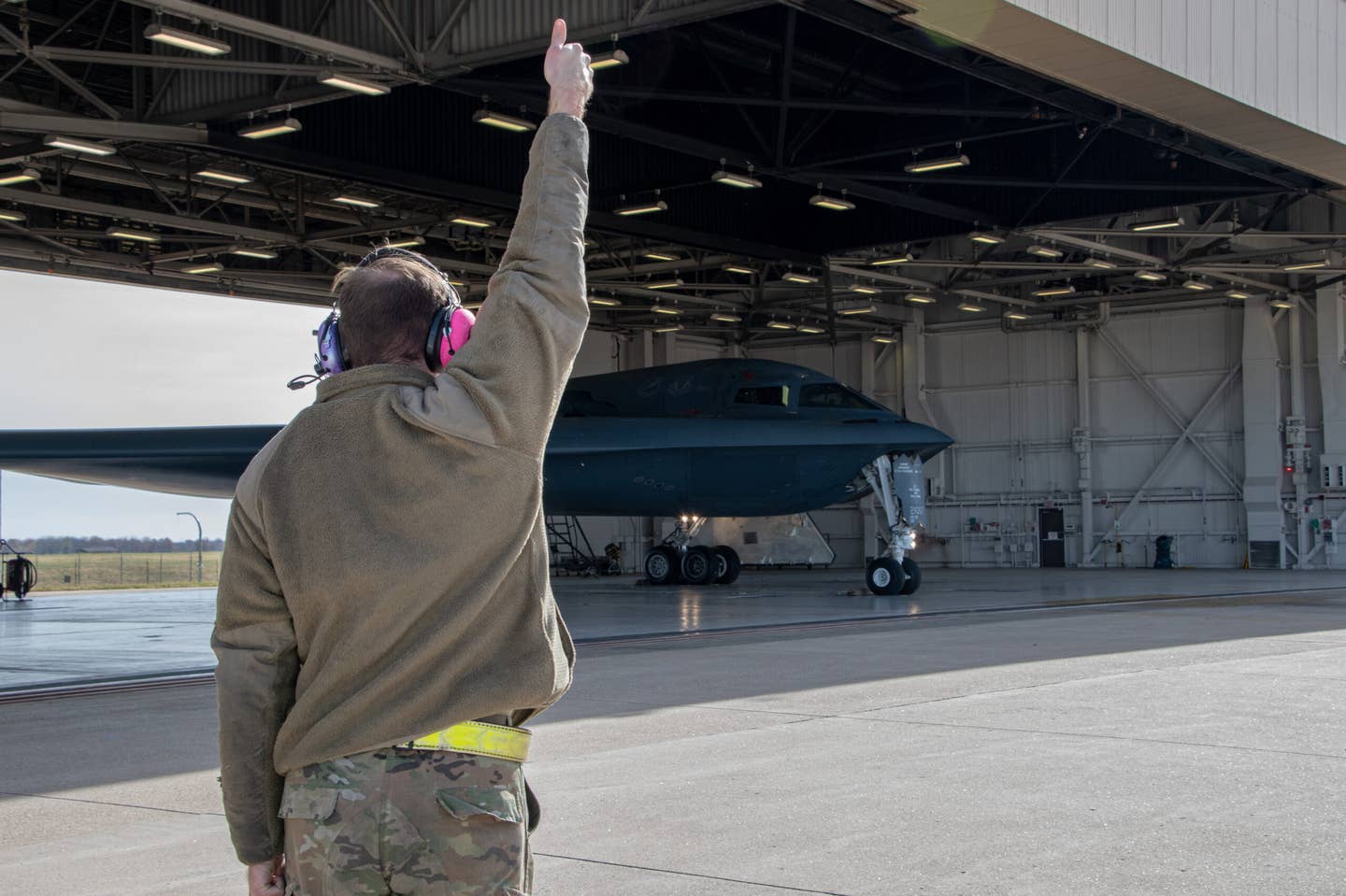 A 509th Bomb Wing maintainer marshals a B-2 stealth bomber before takeoff at Whiteman Air Force Base. <em>U.S. Air National Guard photo by Airman 1st Class Phoenix Lietch</em>