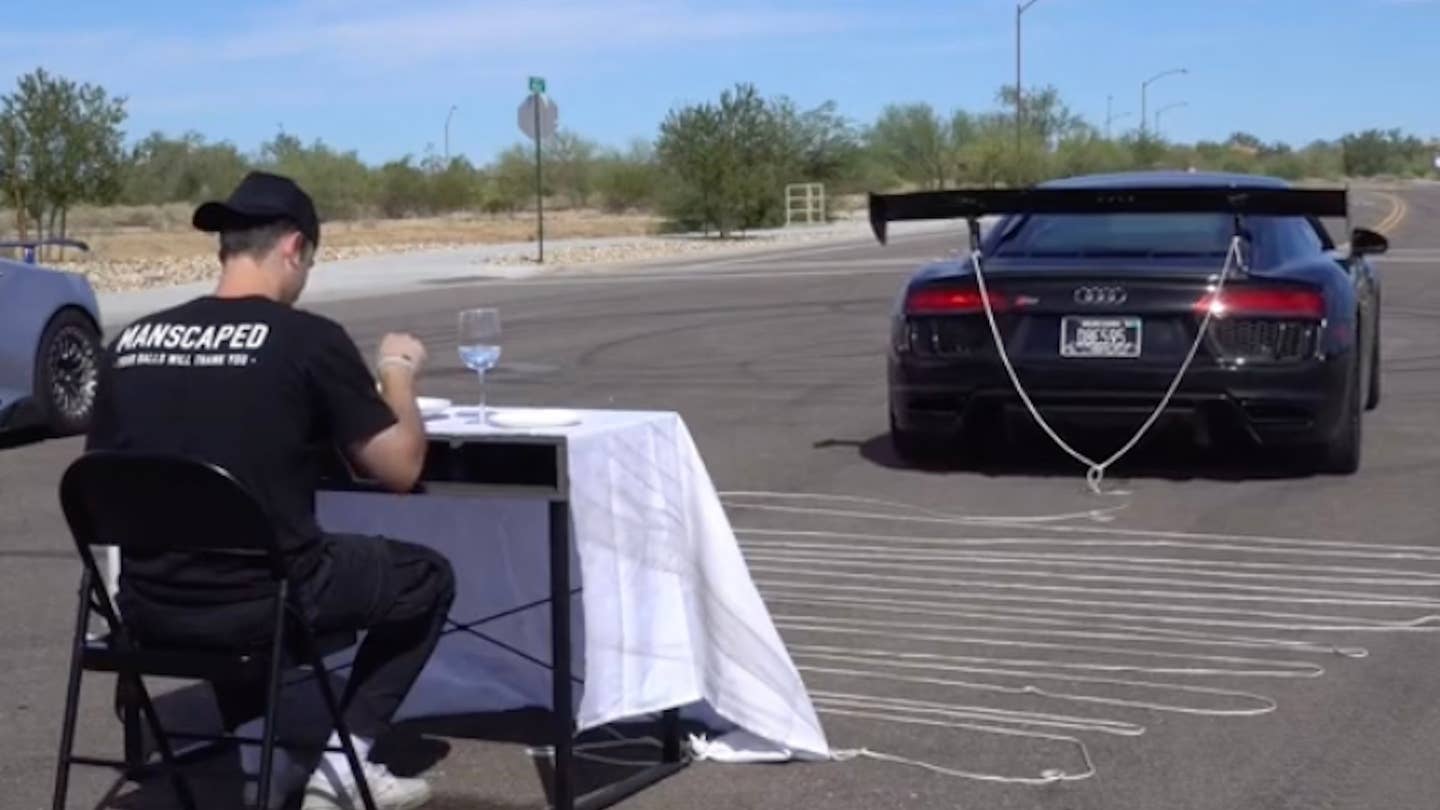 An Audi R8 staged up attached to a tablecloth in preparation to yank it off
