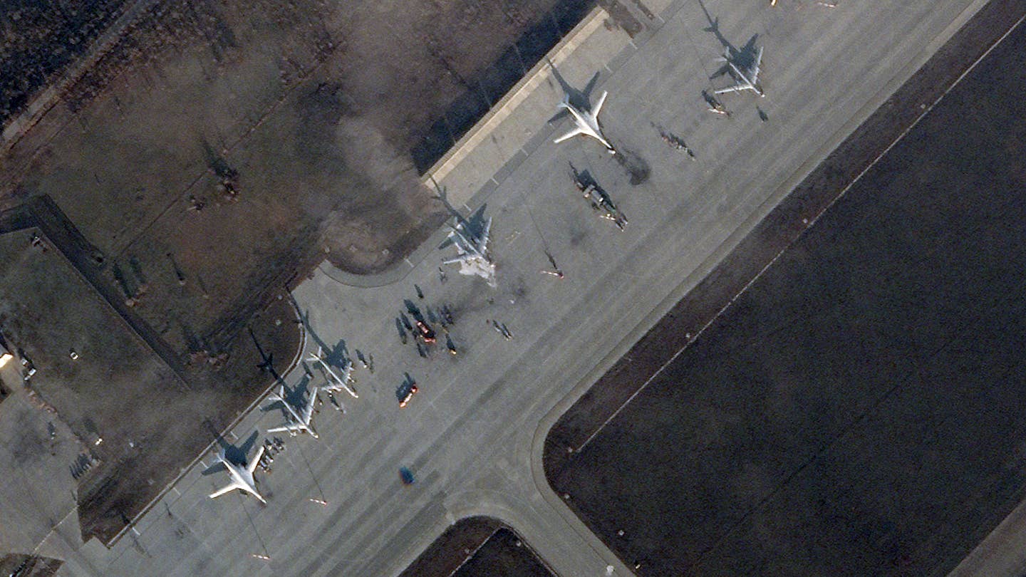 A satellite image of Engels Air Base, taken at 7:00 am UTC this morning, showing a Tu-95MS doused in foam after it apparently caught fire, likely as a result of the drone strike yesterday. Note also the scorch marks on the tarmac and fire trucks adjacent to the bomber. This may well indicate the point at which the drone impacted. <em>PHOTO © 2022 PLANET LABS INC. ALL RIGHTS RESERVED. REPRINTED BY PERMISSION</em>
