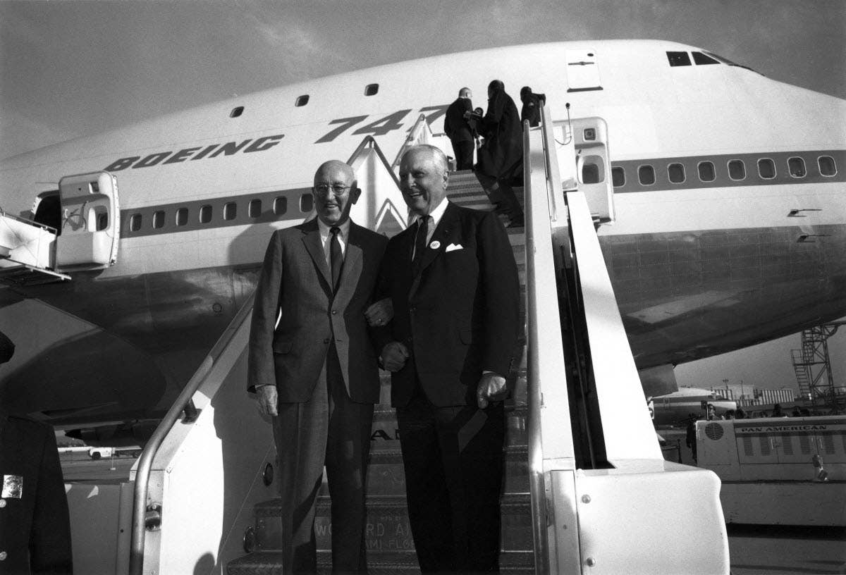 Boeing President Bill Allen (left) and Pan Am CEO Juan Trippe (right) celebrate the launch of the Boeing 747 in 1968. The longtime friends sealed the deal on selling the airplanes to Pan Am with a handshake while on a fishing trip. <em>Boeing</em>