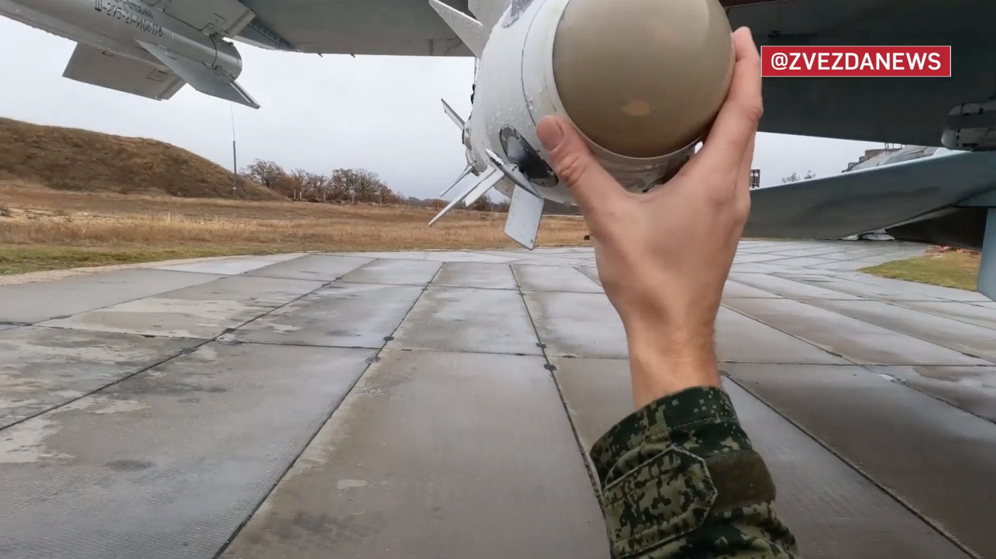 The pilot conducts pre-flight checks on a short-range R-73 series (AA-11 Archer) air-to-air missile. <em>Zvezda TV</em> <em>screencap</em>