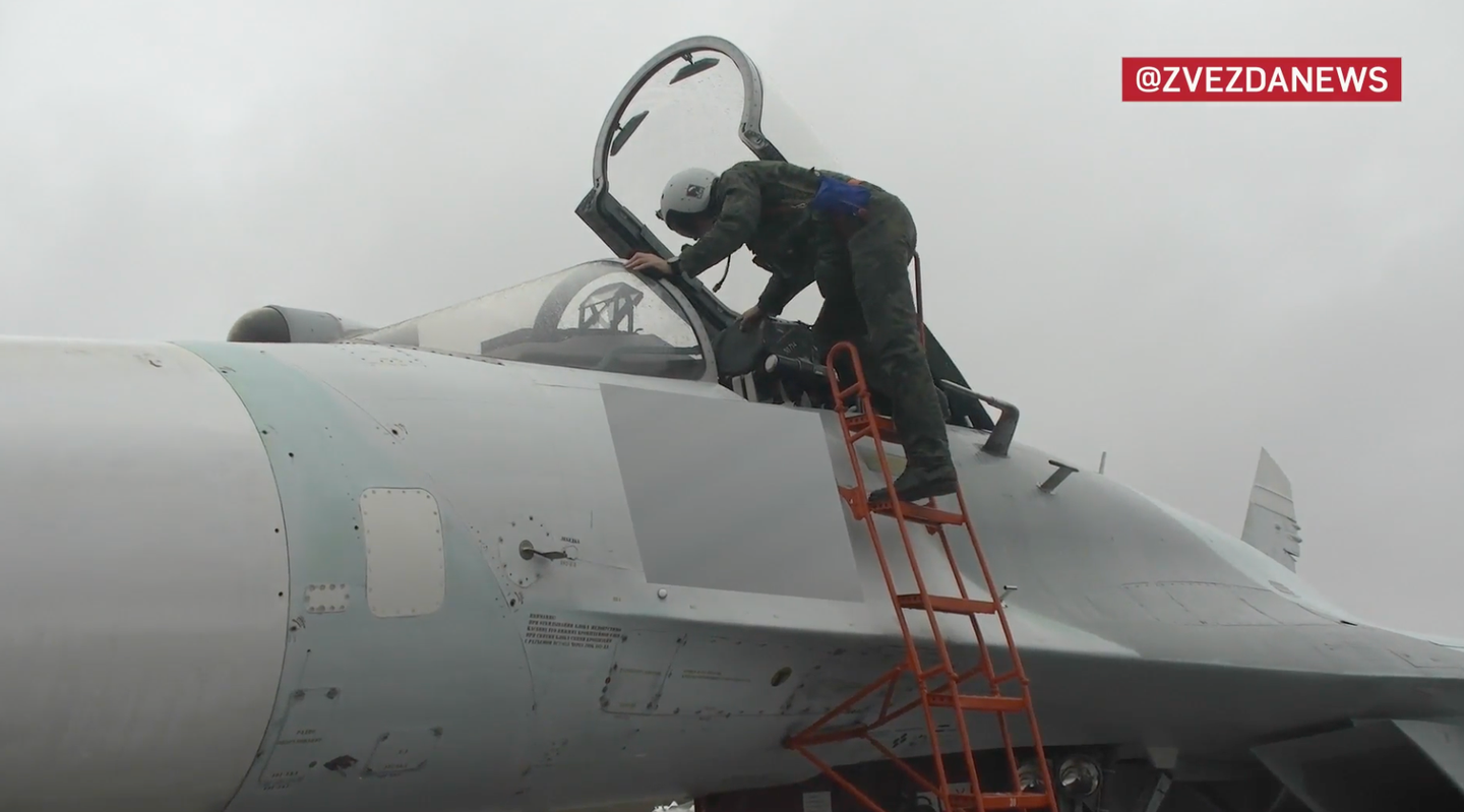The pilot boards the Su-27SM. Note that the code number on the side of the jet has been removed by the censor. <em>Zvezda TV</em> <em>screencap</em>