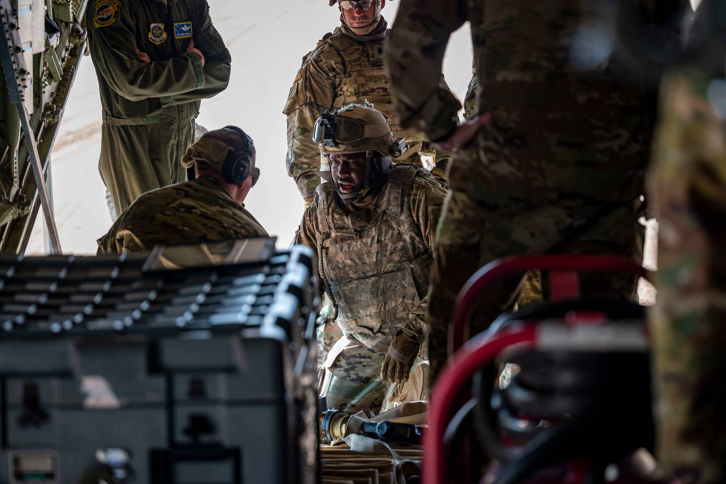 U.S. Army members assigned to the 1st Armored Division discuss preparations with 40th Airlift Squadron airmen to refuel an M1A2 Abrams tank at Fort Bliss. <em>Credit: U.S. Air Force photo by Senior Airman Leon Redfern</em>
