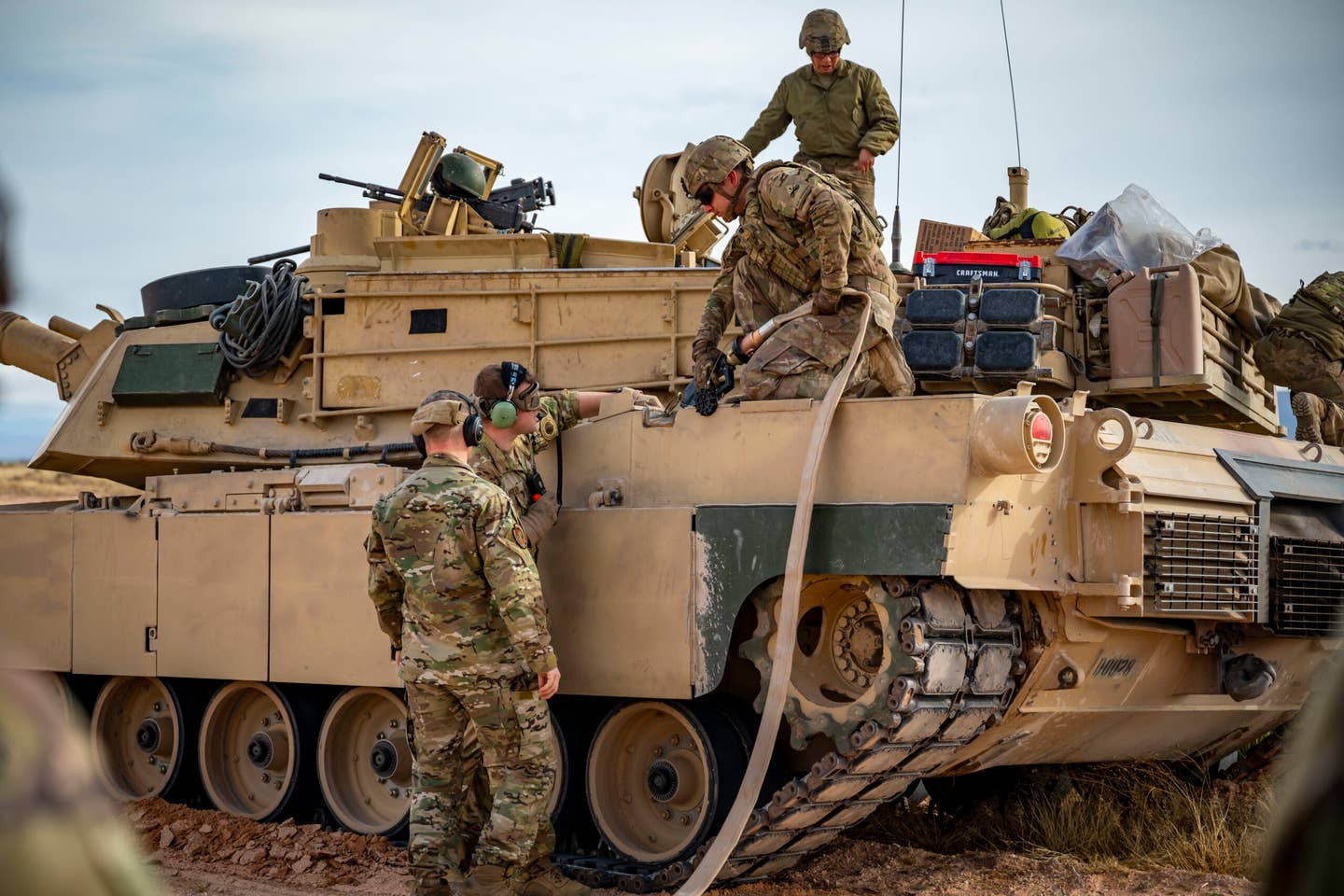 U.S. Army members assigned to the 1st Armored Division and 40th Airlift Squadron Airmen simulate refueling an M1A2 Abrams tank from a C-130J Super Hercules at Fort Bliss, Texas. <em>Credit: U.S. Air Force photo by Senior Airman Leon Redfern</em>