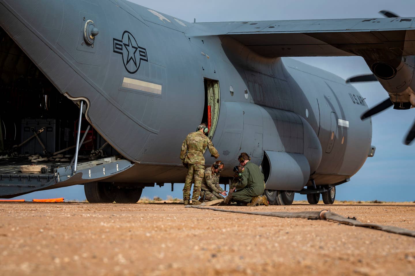 U.S. Airmen from the 40th Airlift Squadron pack up the ERREK after simulating refueling an M1A2 Abrams tank from a C-130J Super Hercules. <em>Credit: U.S. Air Force photo by Senior Airman Leon Redfern</em>
