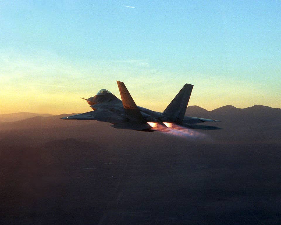 A Edwards AFB F-22 test jet going into afterburner under some amazing lighting conditions. <em>USAF</em>