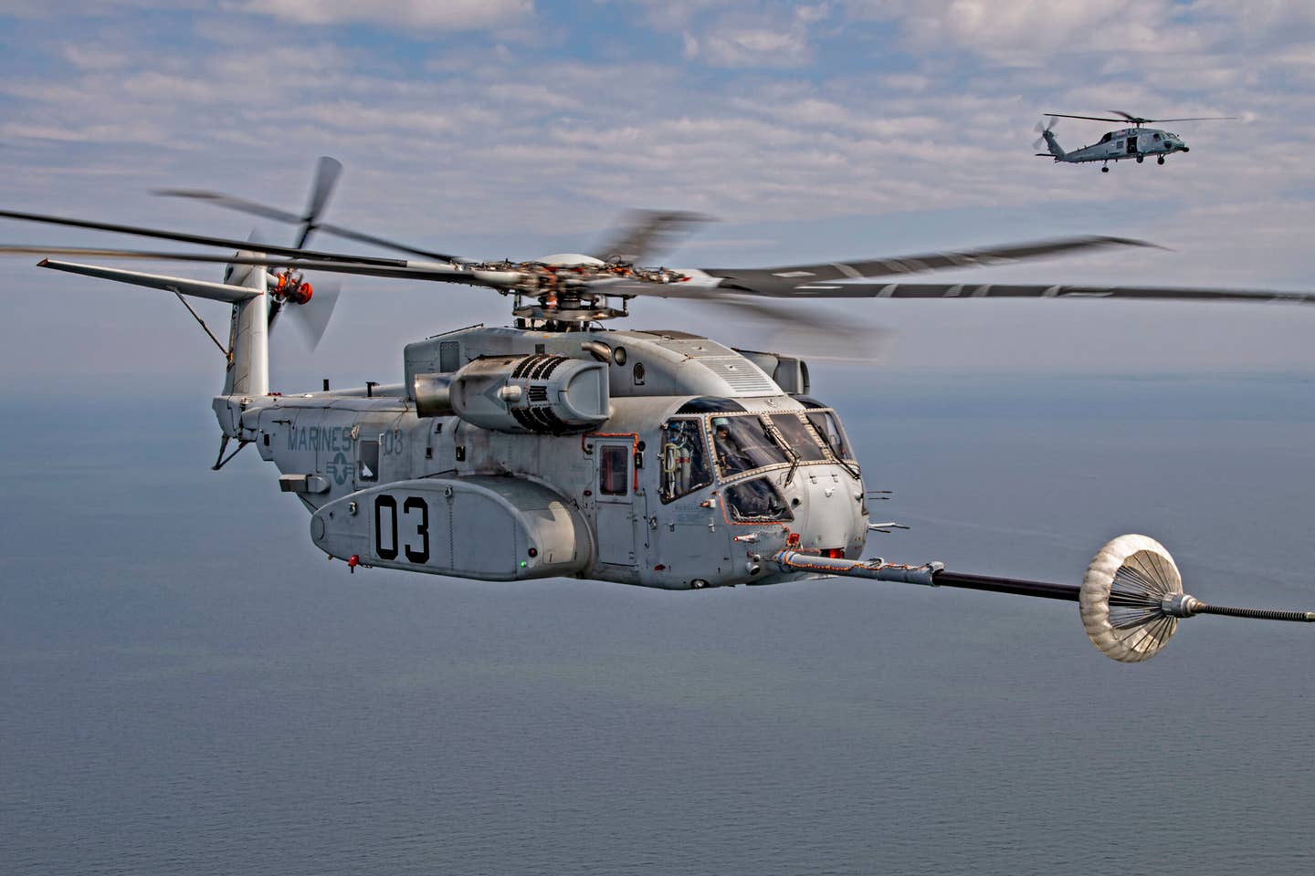 The CH-53K King Stallion successfully plugs into a funnel-shaped drogue towed behind a KC-130J during aerial refueling wake testing over the Chesapeake Bay. <em>Photo by Erik Hildebrandt</em>