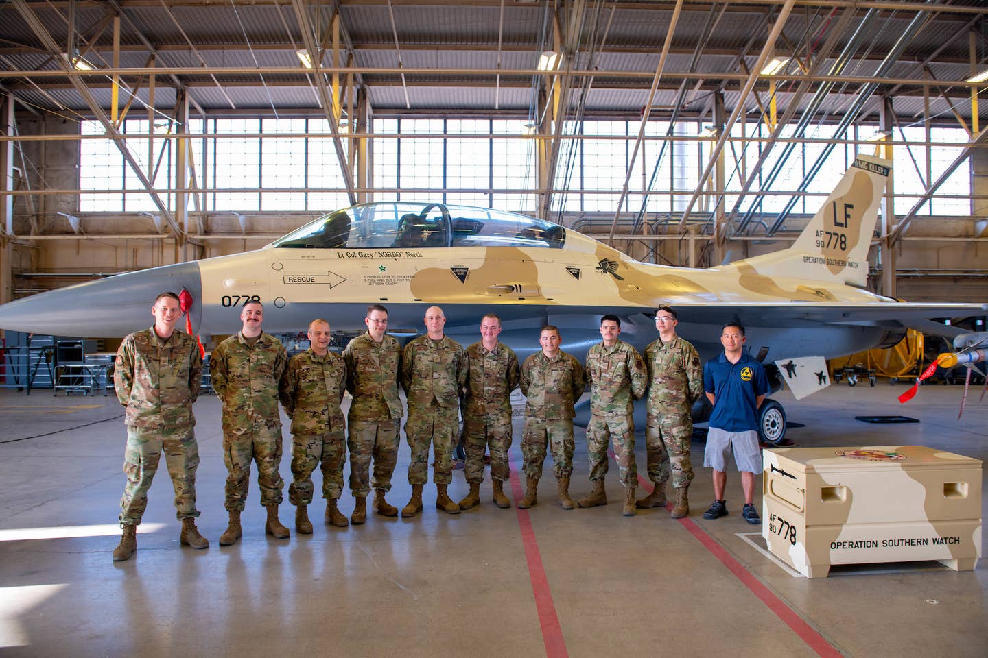 Members of the fabrication flight’s corrosion control team stand with their newly painted F-16D Fighting Falcon during an unveiling ceremony at the 310th Air Maintenance Unit hanger on June 17, 2022, at Luke Air Force Base Phoenix, Arizona. "Lt Col Gary 'NORDO' North" can be seen embossed below the cockpit. <em>USAF photo by Senior Airman Caleb F. Butler</em>