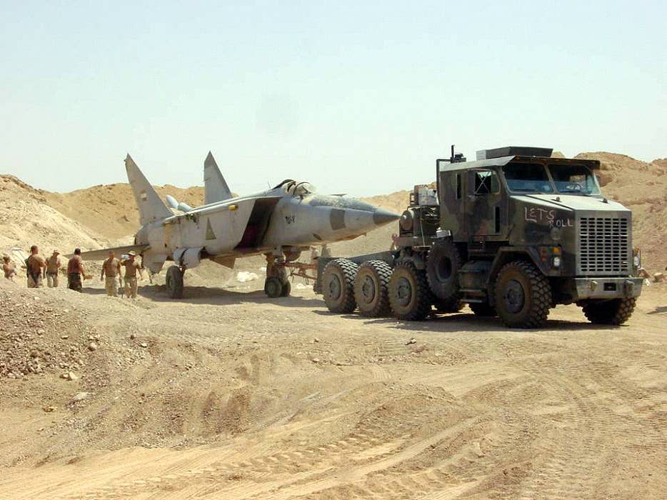 A U.S. military search team discovers a Cold War-era MiG-25R buried beneath the sands in Iraq, 2003. <em>USAF image by MSgt T. Collins</em>
