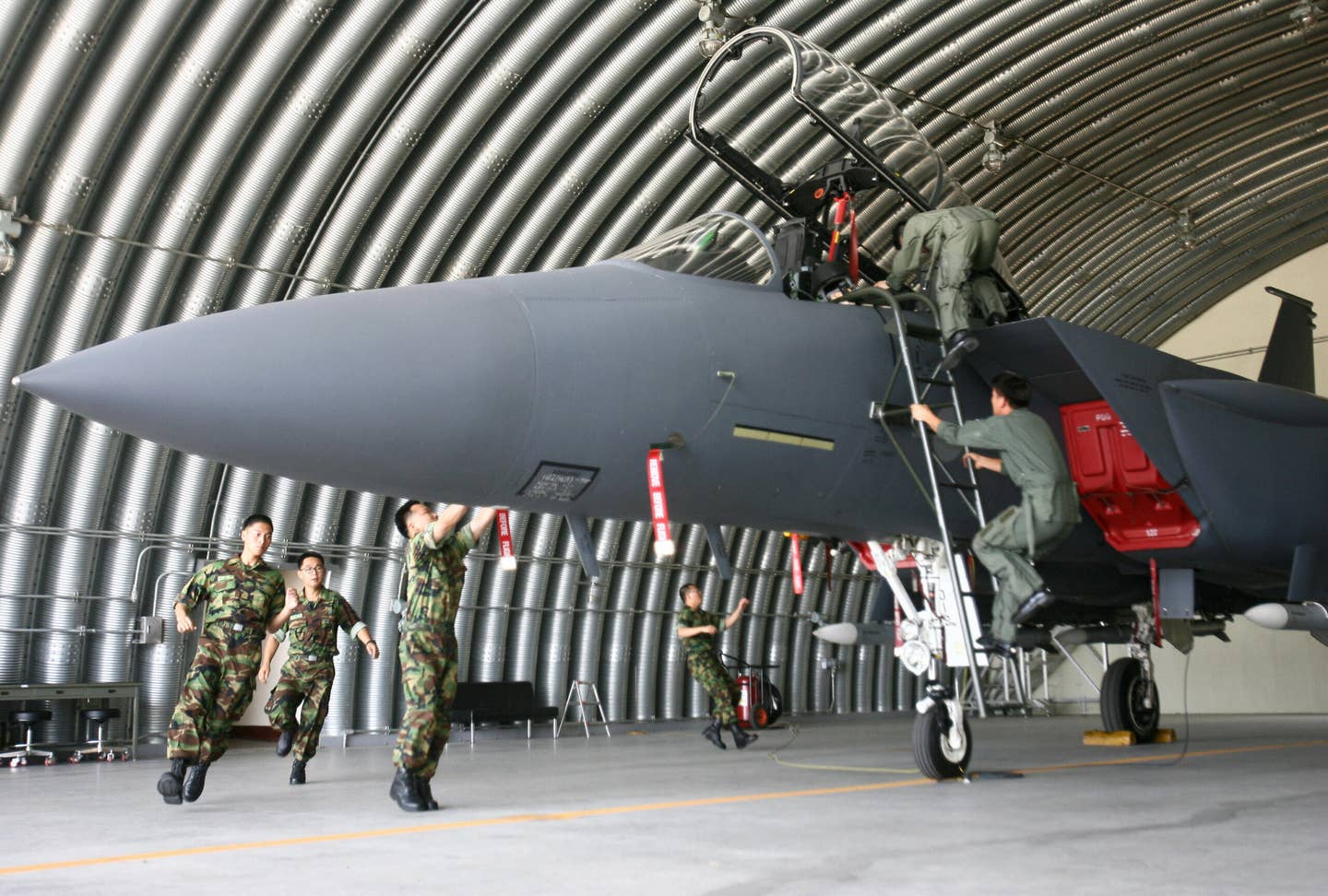ROKAF pilots and maintainers race to launch an F-15K Slam Eagle fighter jet from a shelter at an airbase in the southern city of Daegu. <em>WON DAI-YEON/AFP via Getty Images</em>