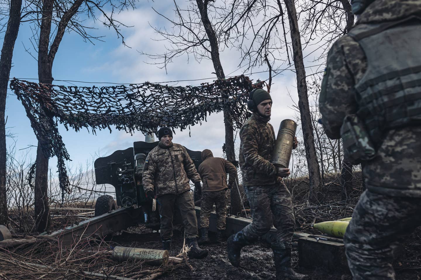 Ukrainian soldiers are seen preparing for artillery fire on the Donbas frontline in Ukraine on December 28, 2022. A previously fired and reloaded OF-25T case can be seen both on the ground and in the center soldier's hands. <em>Photo by Diego Herrera Carcedo/Anadolu Agency via Getty Images</em>