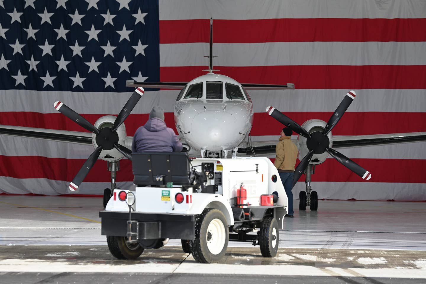 Maintenance specialists from the Wisconsin Air National Guard bring an RC-26B back into a hangar at Dane County Regional Airport following its final flight on December 28, 2022. <em>U.S. Air National Guard photo by Senior Master Sgt. Paul Gorman</em>