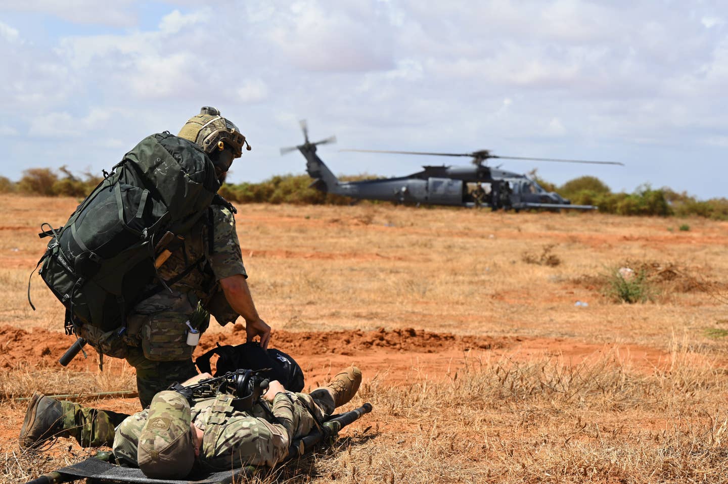A U.S. pararescueman prepares to move a simulated casualty to an HH-60W combat rescue helicopter during a casualty evacuation (CASEVAC) exercise at an undisclosed Combined Joint Task Force-Horn of Africa area of responsibility, December 8, 2022. <em>U.S. Air Force photo by Tech. Sgt. Jayson Burns</em>