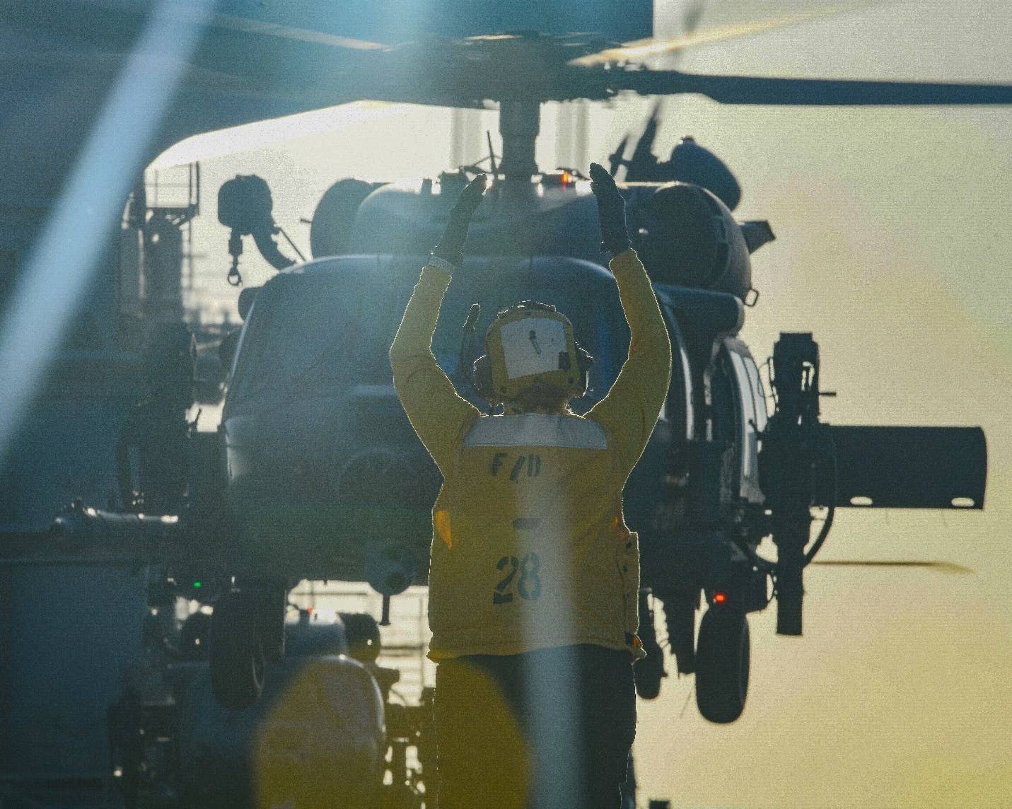 Aviation Boatswain's Mate (Handling) 3rd Class Alexis Woods directs an HH-60W helicopter from Moody Air Force Base as it departs the flight deck of USS <em>Hershel Williams</em>, Dec. 31, 2022. <em>Credit: U.S. Navy photo by Mass Communication Specialist 2nd Class Conner D. Blake/Released</em>
