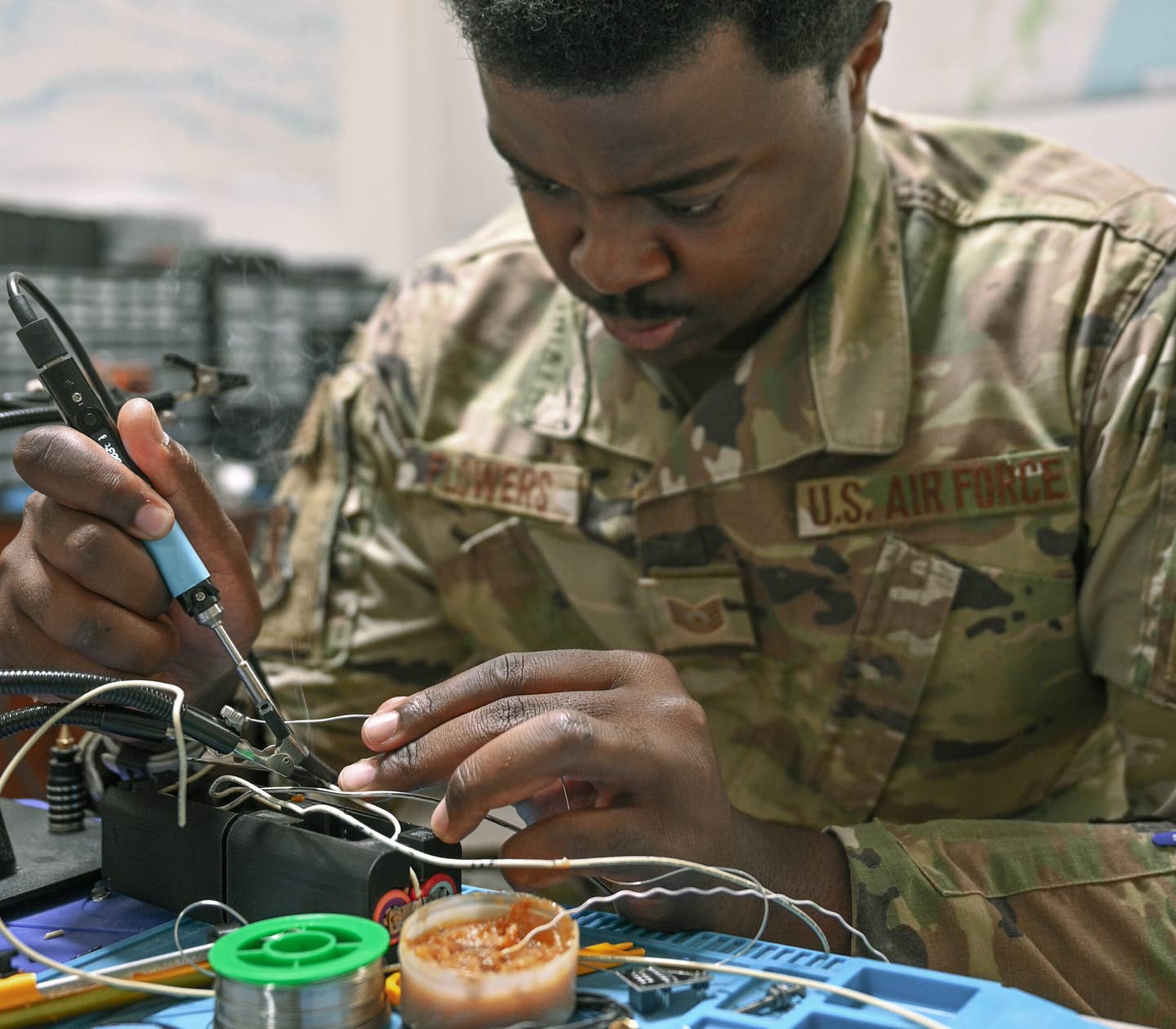 U.S. Air Force Tech. Sgt. Malik Flowers, an installation spectrum manager with Task Force 99, solders components at the TF-99 lab at Al Udeid Air Base, Qatar, November 18, 2022. <em>Credit: U.S. Air Force Photo by Senior Airman Micah Coate</em>