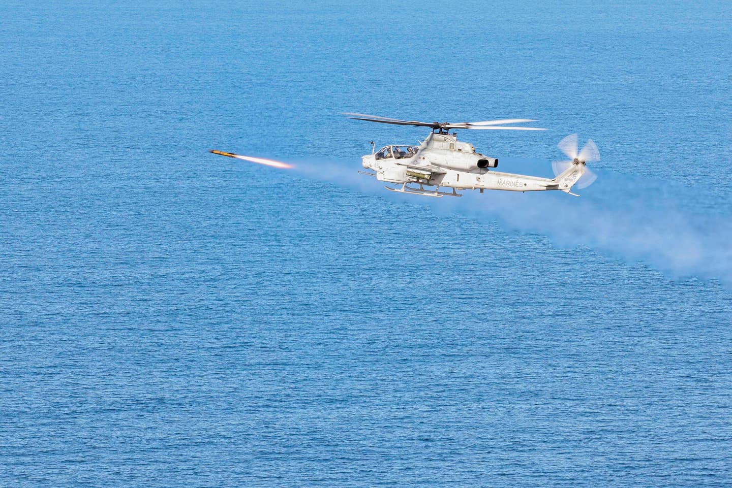 An AH-1Z helicopter from Marine Light Attack Helicopter Squadron 369 fires a JAGM at a moving maritime target during Exercise Steel Knight 23, over the Pacific Ocean, in December 2022. <em>U.S. Marine Corps photo by Sgt. Samuel Fletcher</em>