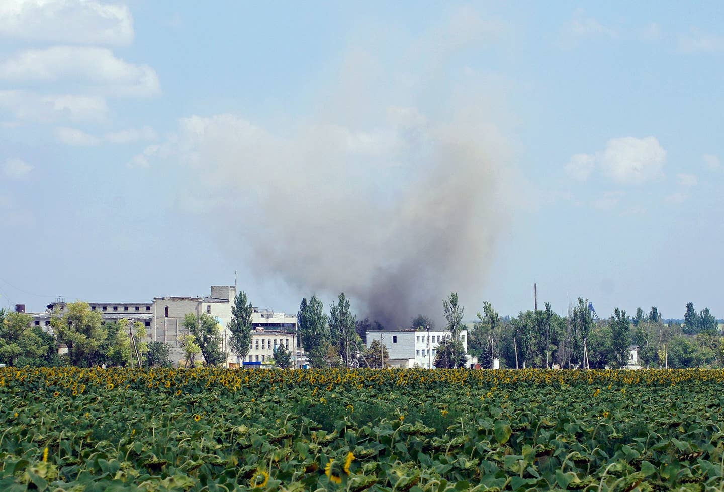 A picture shows smoke rising over buildings during shelling in the village of Maryinka, a suburb of Donetsk in eastern Ukraine, on August 5, 2014. (Photo by ANDREY KRASNOSCHEKOV/AFP via Getty Images)