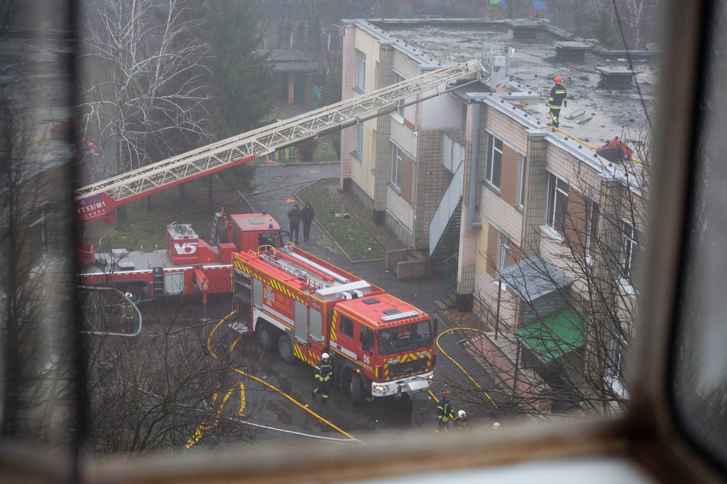 Firefighters work on the site where a helicopter crashed into a school in the city of Brovary outside of Kyiv. At least 17 people have been killed. <em>Photo by Oleksii Chumachenko/Anadolu Agency via Getty Images</em>