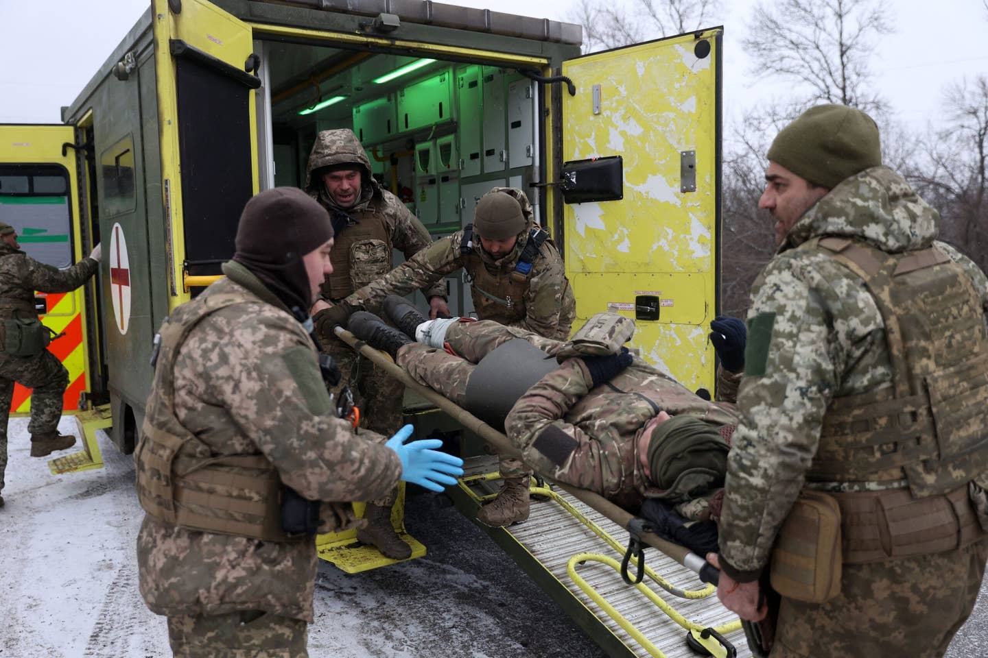 Medics of the Ukrainian Army evacuate a wounded soldier on a road near Soledar. (Photo by Anatolii Stepanov / AFP) (Photo by ANATOLII STEPANOV/AFP via Getty Images)