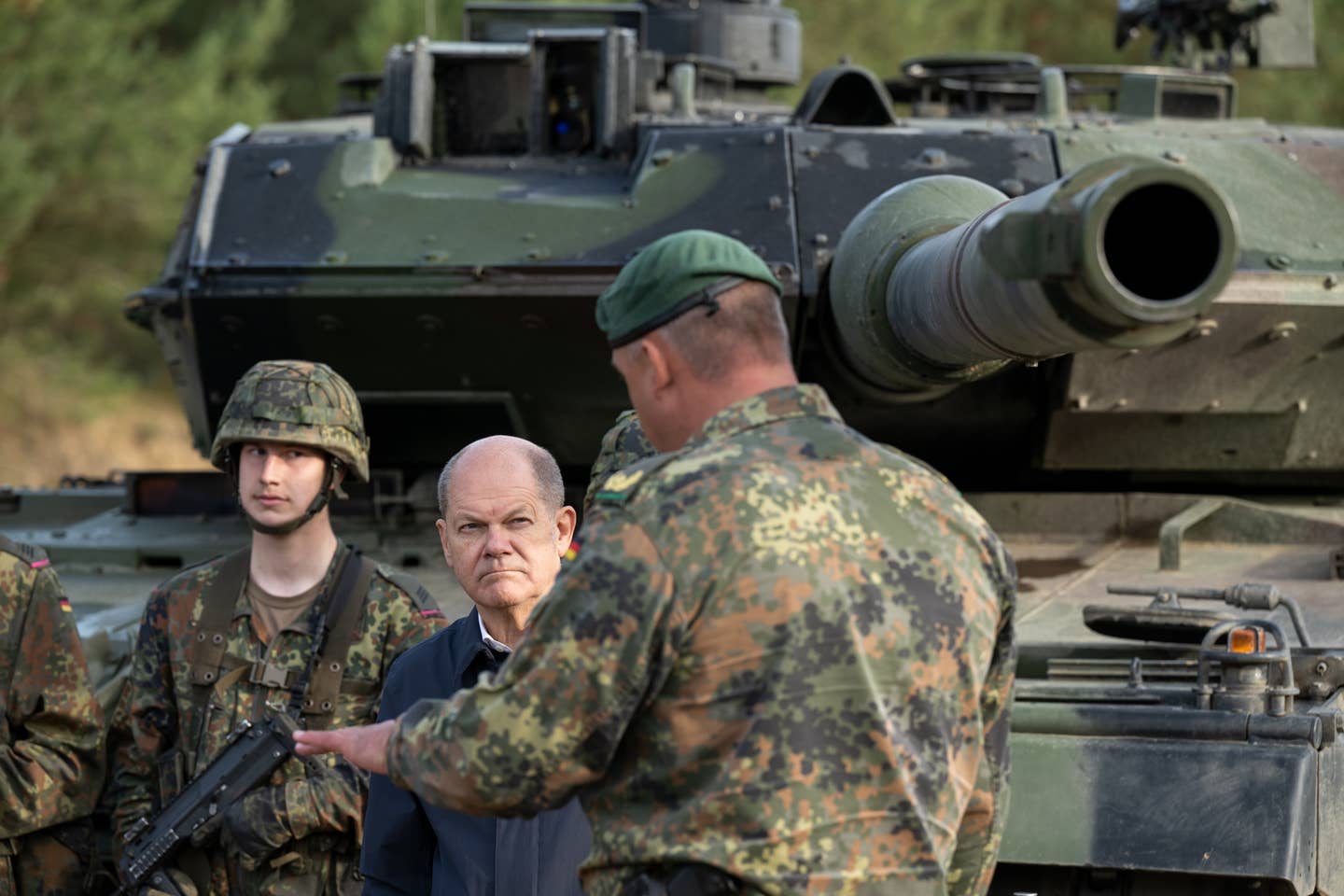 German Chancellor Olaf Scholz stands next to a Leopard 2 main battle tank while speaking with soldiers during a visit to the German Army training center in Ostenholz on October 17, 2022. <em>Photo by David Hecker/Getty Images</em>