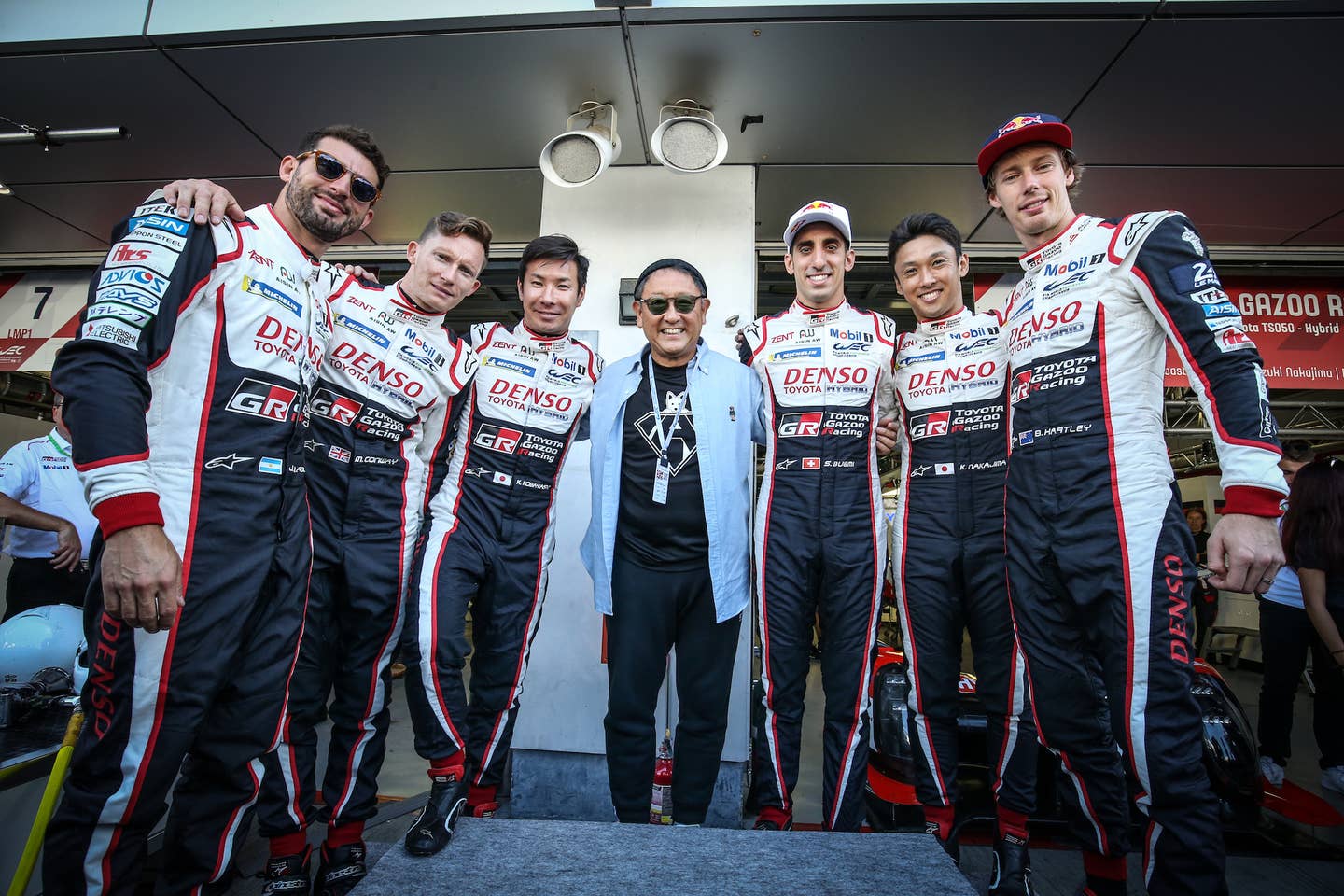 FUJI, JAPAN - OCTOBER 06: (L to R): Jose Maria Lopez of Argentina and Toyota Gazoo Racing; Mike Conway of Great Britain and Toyota Gazoo Racing; Kamui Kobayashi of Japan and Toyota Gazoo Racing; Akio Toyoda of Japan and President of the Toyota Motor Corporation; Sebastien Buemi of Switzerland and Toyota Gazoo Racing; Kazuki Nakajima of Japan and Toyota Gazoo Racing; and Mike Conway of Great Britain and Toyota Gazoo Racing, in the pit lane on October 6, 2019 at the World Endurance Chapionship at Fuji, Japan. (Photo by James Moy Photography/Getty Images)