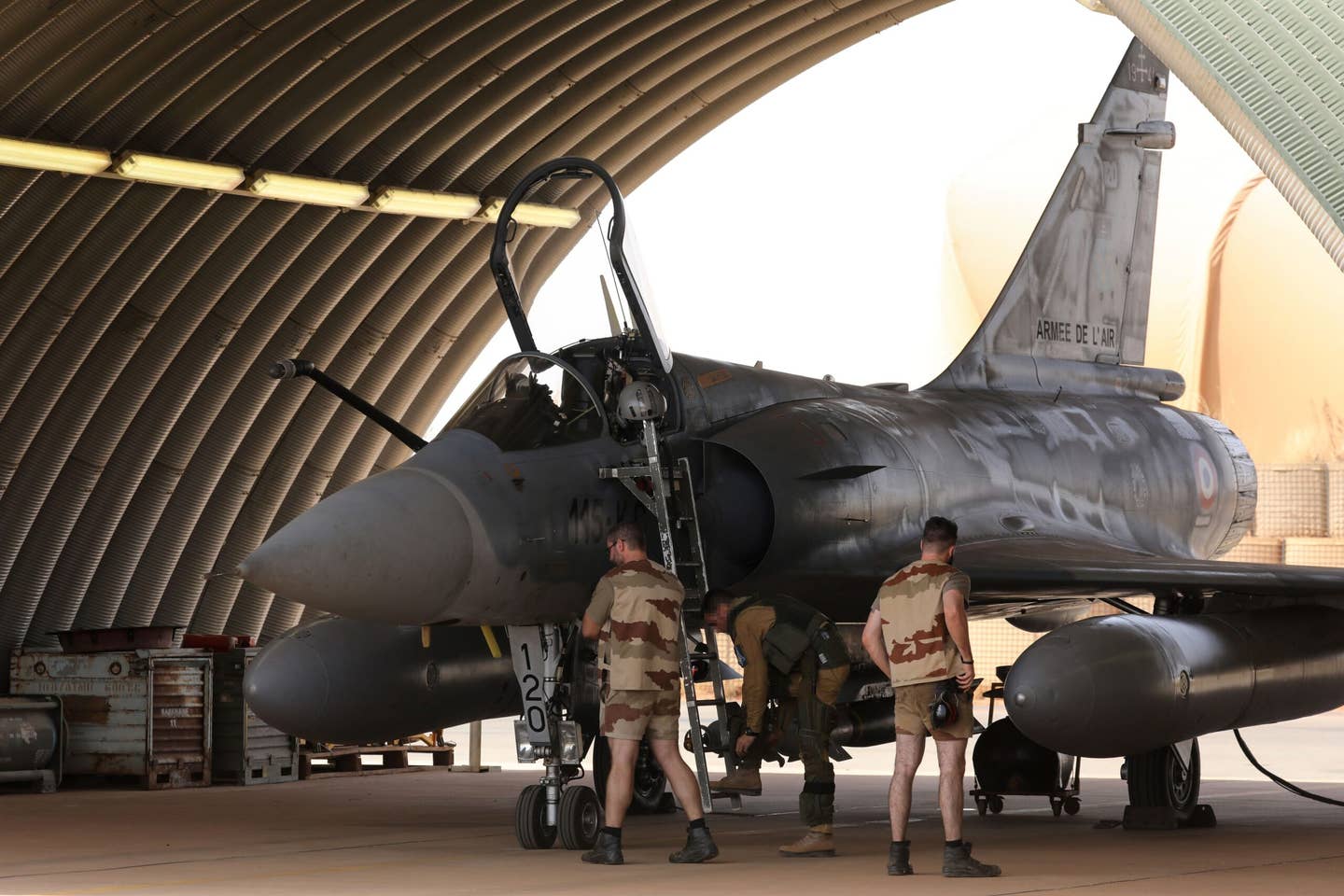 A French Air Force pilot boards a Mirage 2000 aircraft, as the ground crew prepares the jet to take off from the French airbase in Niamey, Niger, in 2017. <em>LUDOVIC MARIN/AFP via Getty Images</em>