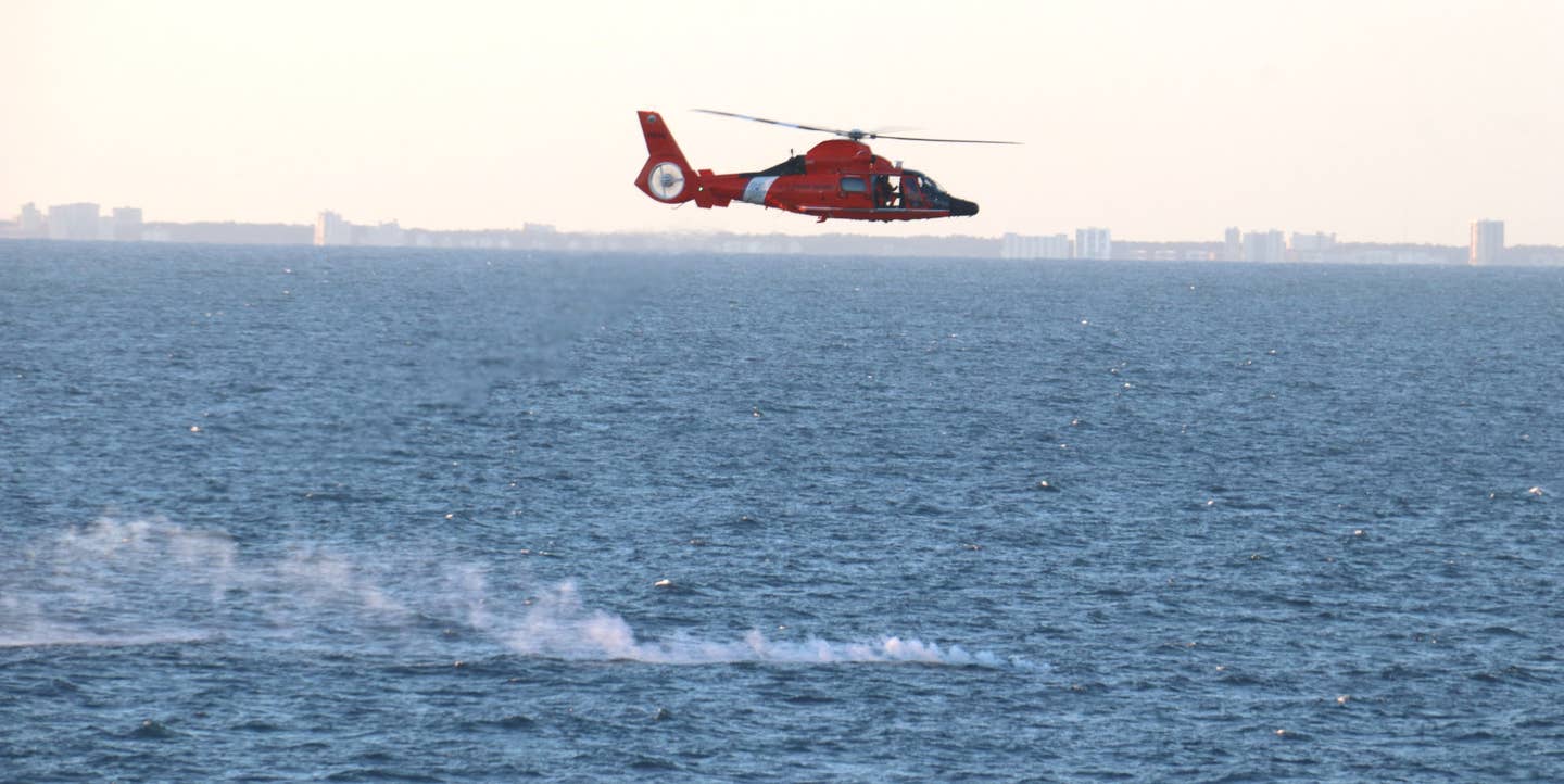 A U.S. Coast Guard MH-65 Dolphin helicopter supports the Chinese surveillance balloon recovery efforts. <em>USN</em>
