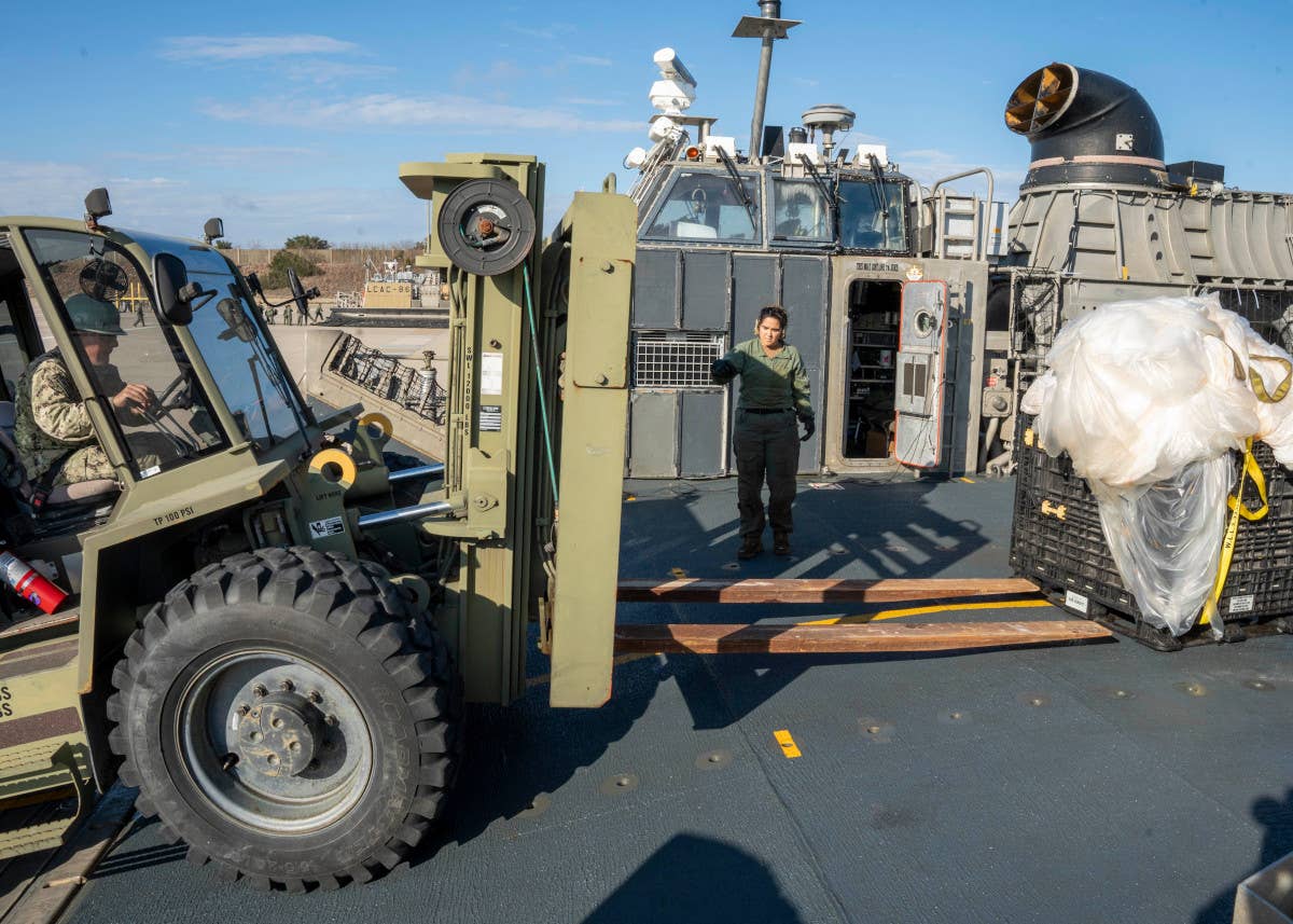 U.S. Navy personnel prepare to move portions of a Chinese surveillance balloon that were recovered off the coast of South Carolina and then carried ashore by a Landing Craft Air Cushion (LCAC) hovercraft. <em>USN</em>