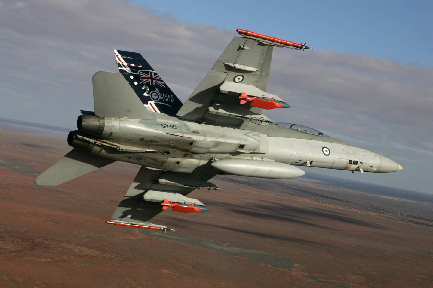 A Royal Australian Air Force F/A-18B Hornet during an early test flight with two 500-pound JDAM-ER bombs at Woomera, South Australia. <em>Australian Defense Force</em>