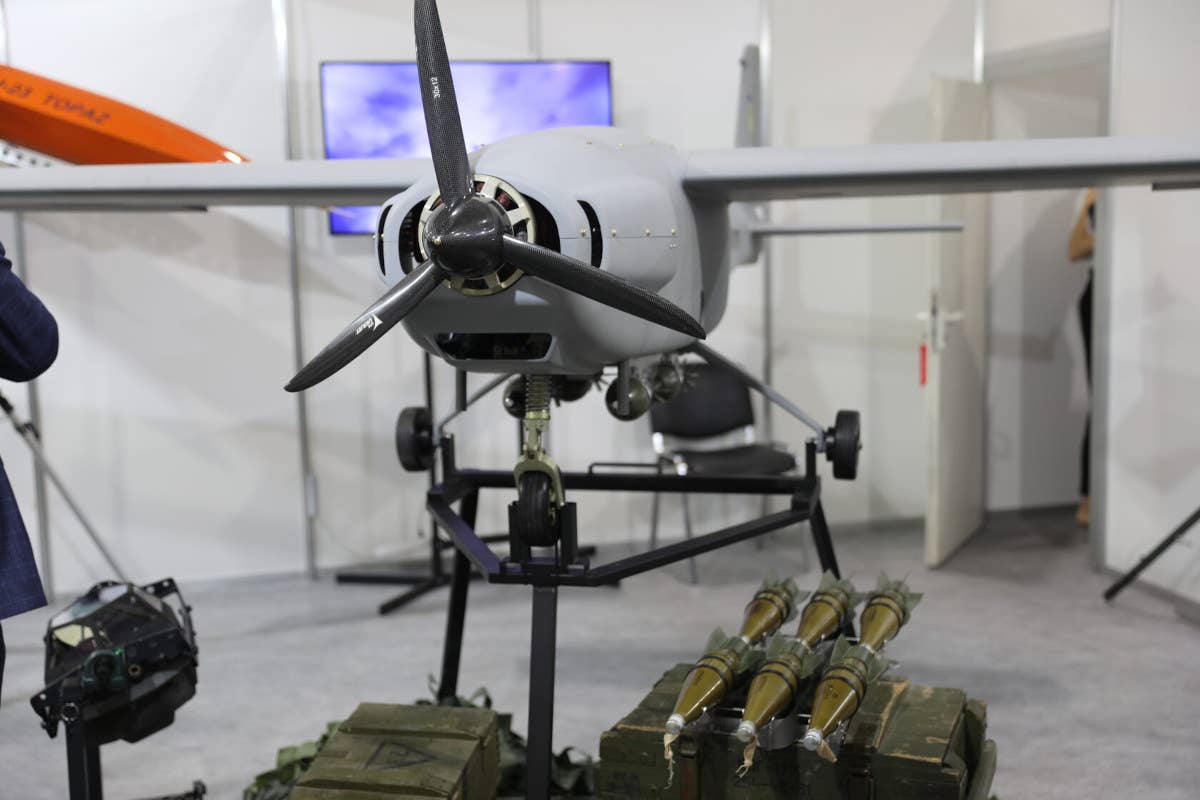 A UJ-22 on display shown with four mortar rounds reconfigured as small air-dropped munitions on racks under its central fuselage. At the bottom right there are also rocket-propelled grenade warheads configured for aerial use. <em>UKRJET</em>