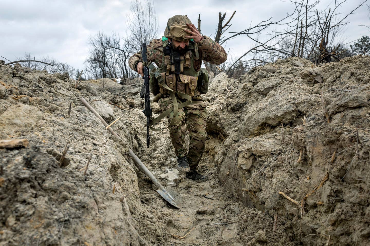 A Ukrainian Army medic runs through a partially dug trench along the front line outside of Bakhmut, Ukraine, on March 5, 2023. Russian forces have been attacking Ukrainian troops as part of an offensive to encircle Bakhmut in the eastern Donbas region. <em>Photo by John Moore/Getty Images</em>