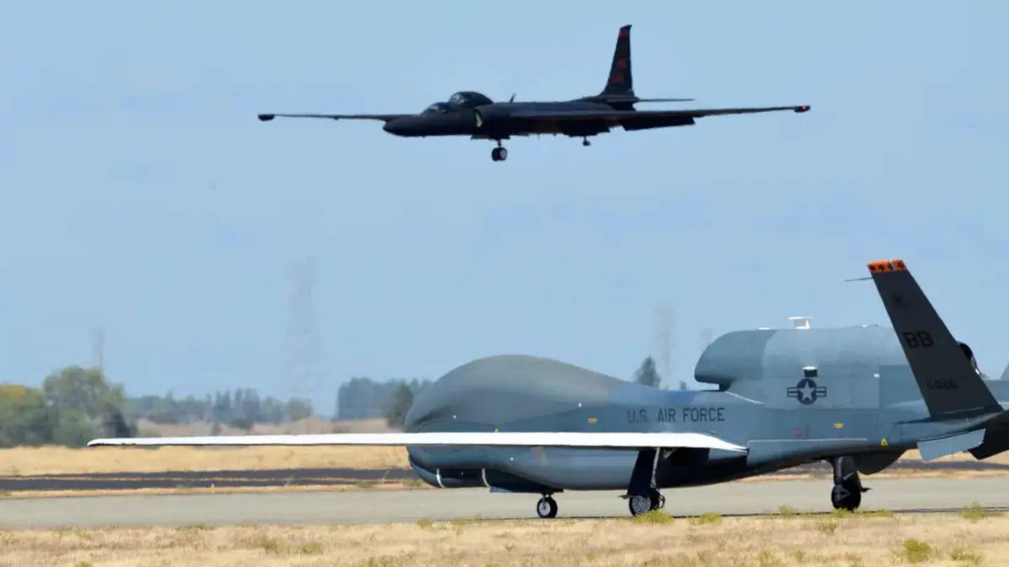 An RQ-4 Global Hawk in the foreground on a taxiway at Beale Air Force Base in California, with a two-seat TU-2S Dragon Lady trainer seen coming in to land in the background.&nbsp;<em>USAF</em>