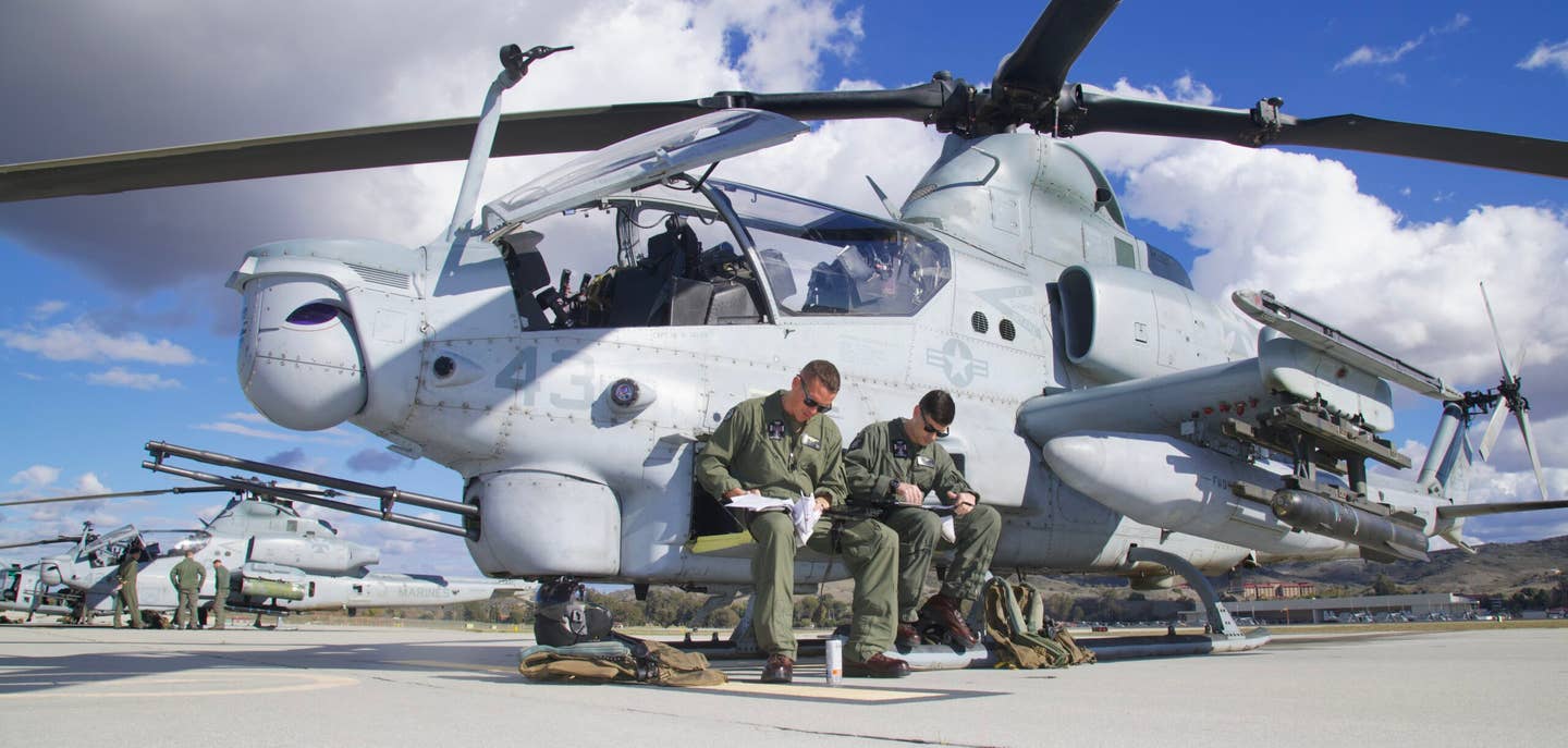 A crew completing paperwork on the hatch of their AH-1Z. (Author)