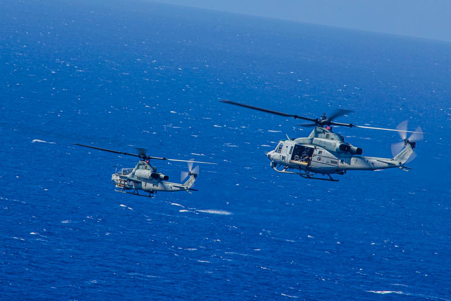 U.S. Marines with Marine Light Helicopter Attack Squadron 367 operate an AH-1Z Viper and UH-1Y Venom during a joint maritime strike exercise with U.S. Navy Helicopter Maritime Strike Squadron 37 over Pacific Missile Range Facility, Hawaii, June 9, 2020. (U.S. Marine Corps photo by Lance Cpl. Jacob Wilson)