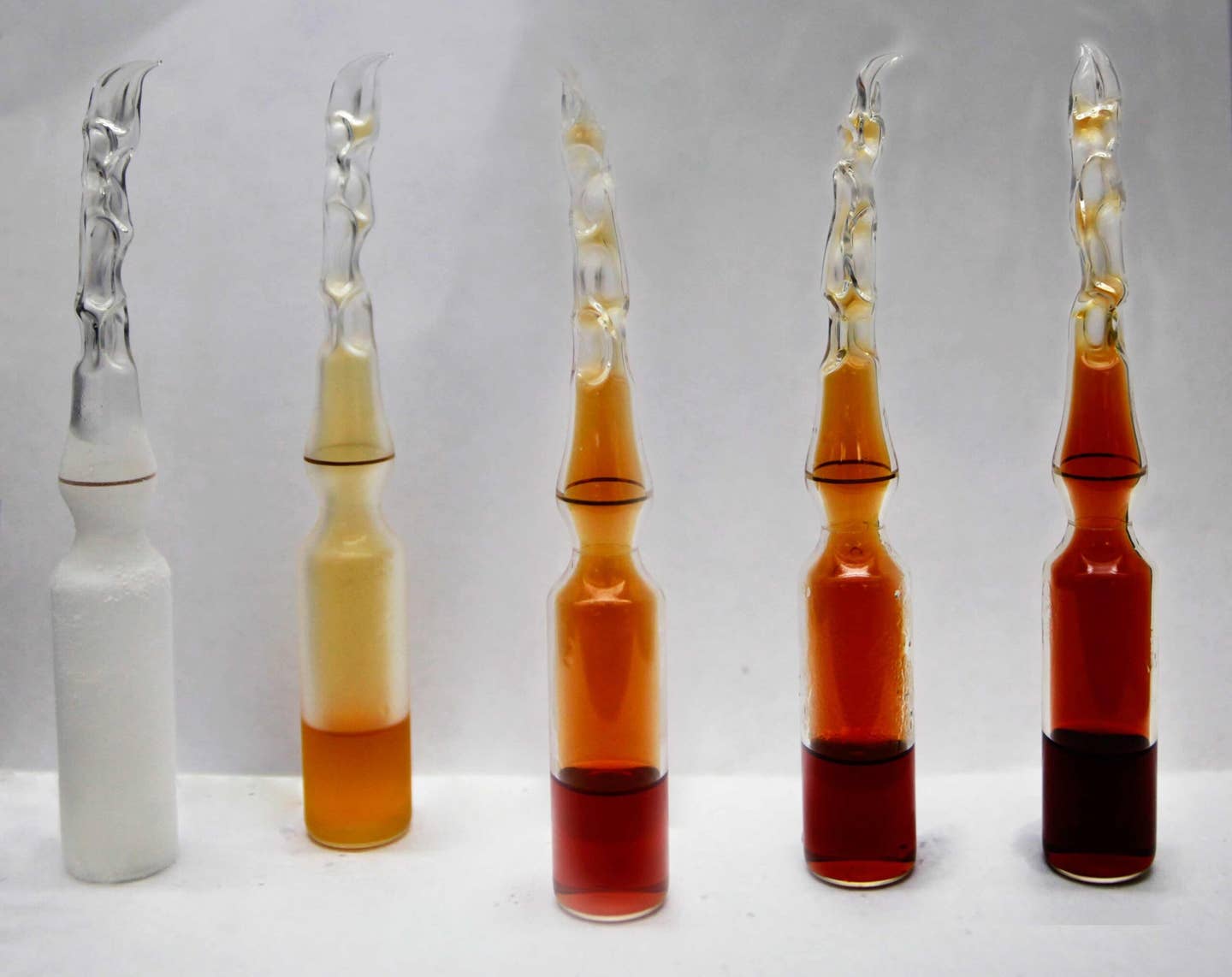 An overlay of the same 99.9% pure NO2/N2O4 sealed in an ampoule. From left to right -196 °C, 0 °C, 23 °C, 35 °C, 50 °C. <em>Efram Goldberg, Florida Institute of Technology, Dr. Knight Research Group via Wikimedia Commons</em>