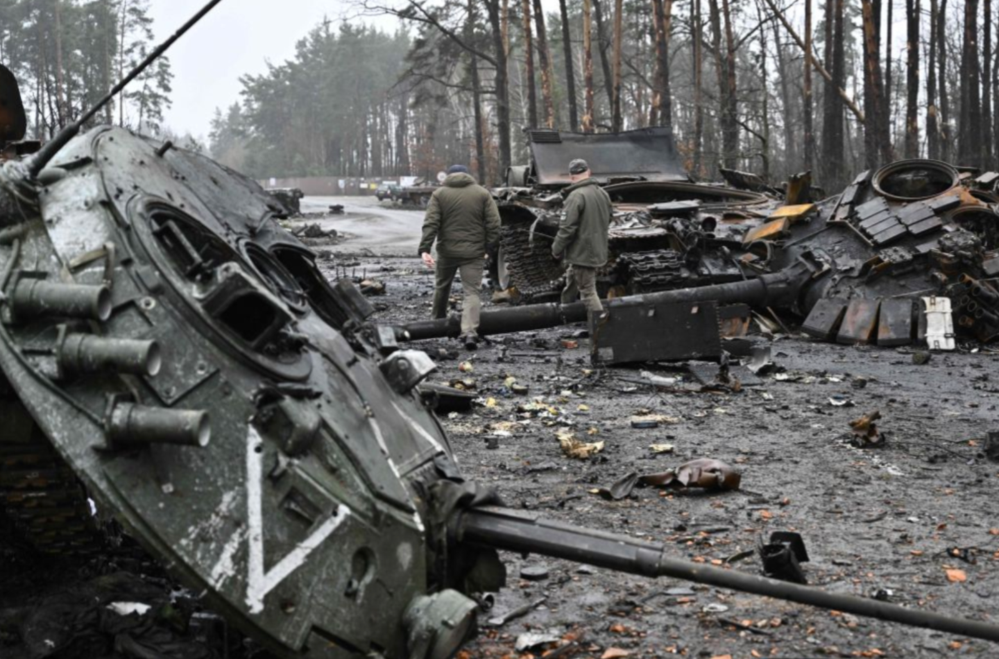 Ukrainian servicemen walk next to destroyed Russian tanks and armored personnel carriers in Dmytrivka village, west of Kyiv, on April 2, 2022. <em>Photo by GENYA SAVILOV/AFP via Getty Images</em>