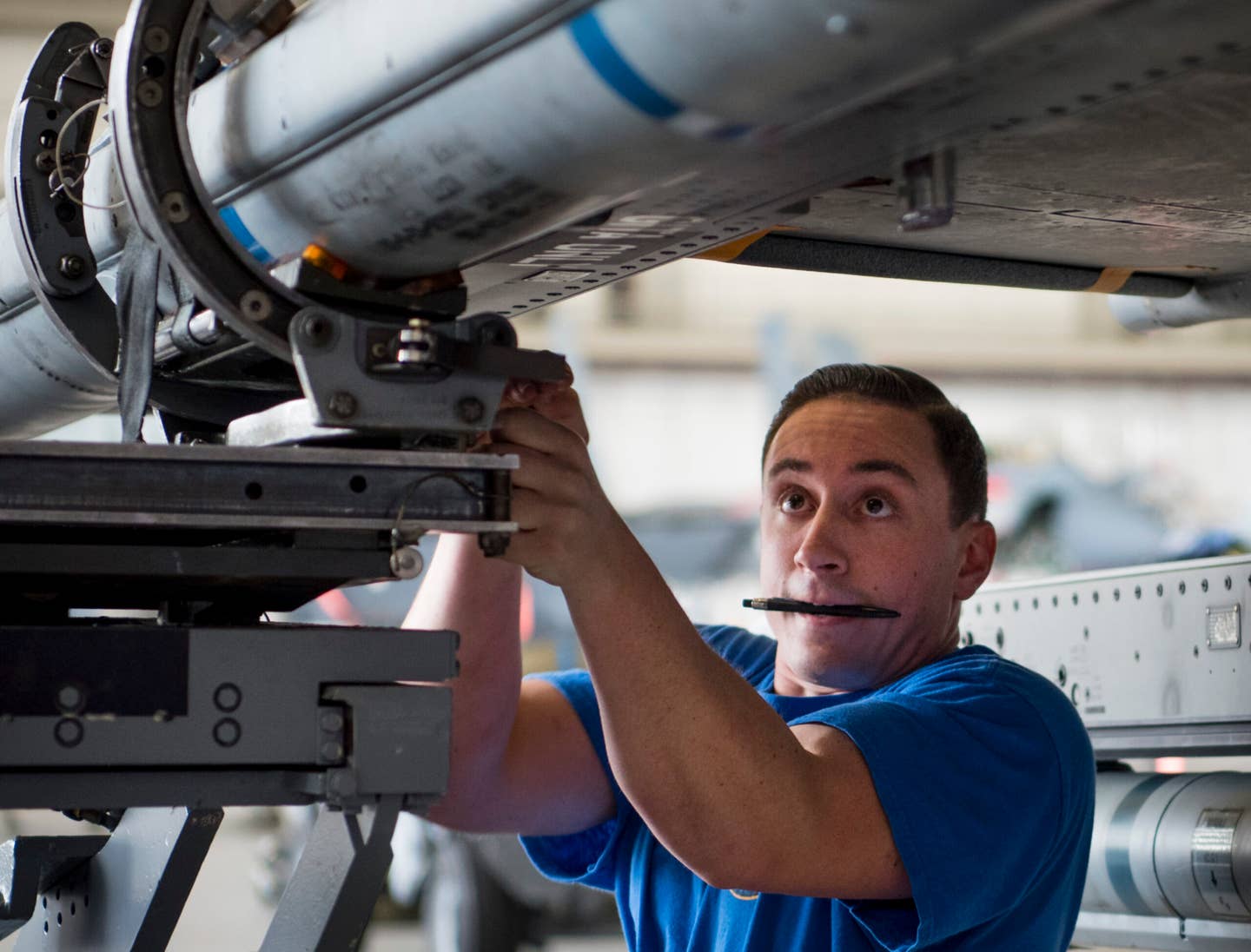Staff Sgt. Trey Riley, 96th Aircraft Maintenance Squadron Blue team, secures an AIM-120 missile onto an F-16 April 13 at Eglin Air Force Base, Fla. The Blue team battled the Red AMU team for weapons loadcrew supremacy during the quarterly competition. The Red team claimed victory this quarter. (U.S. Air Force photo/Samuel King Jr.)
