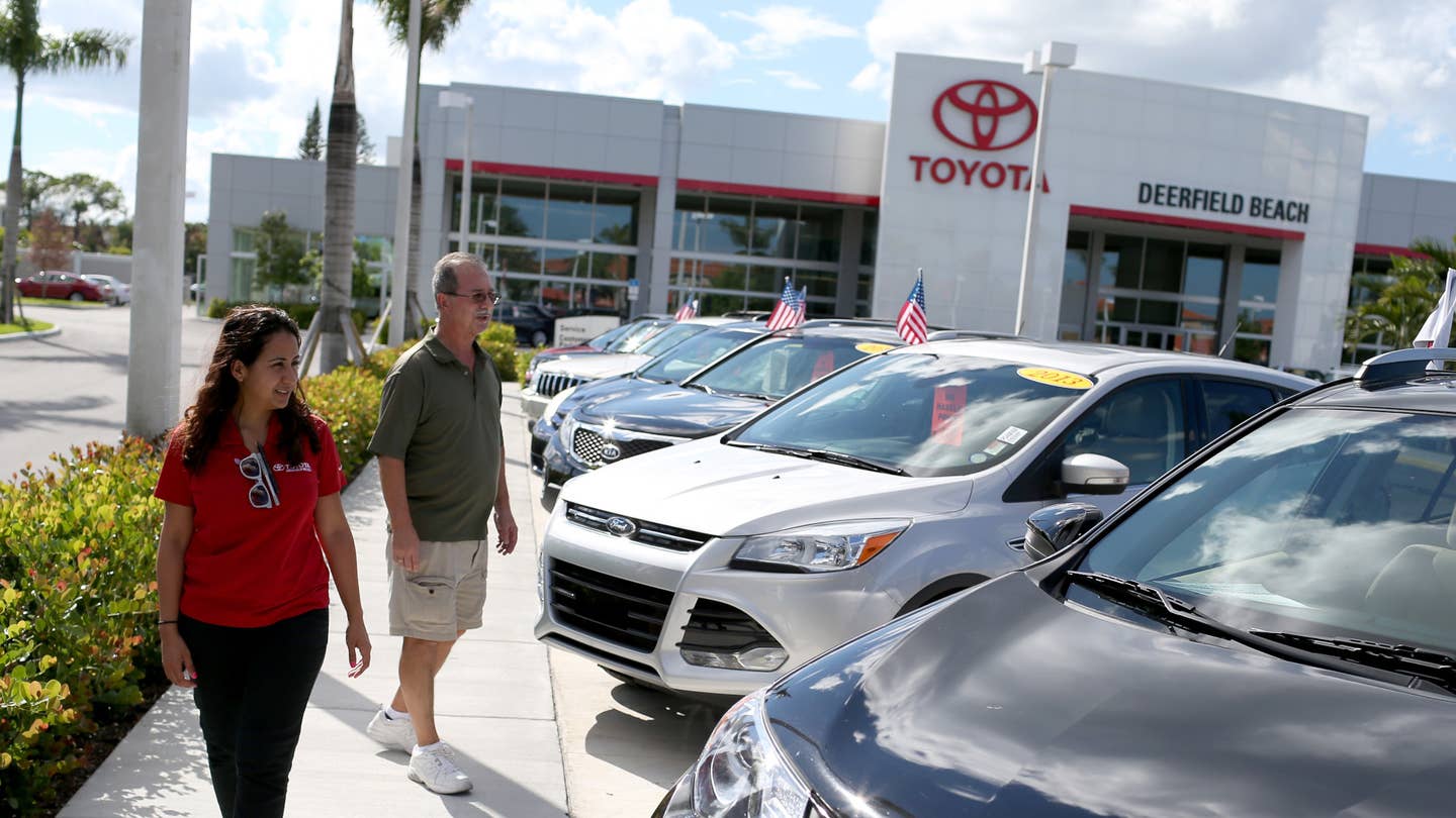 DEERFIELD BEACH, FL - OCTOBER 02:  Natalie Pena (L) shows vehicles to Ruben Mendoza as he shops for vehicles at the Toyota of Deerfield dealership on the day that Warren Buffett's Berkshire Hathaway announced it was acquiring the Van Tuyl Group the owner of the dealership on October 2, 2014 in Deerfield Beach, Florida. With the acquisition Buffett gets the largest privately held chain of auto dealerships.  (Photo by Joe Raedle/Getty Images)