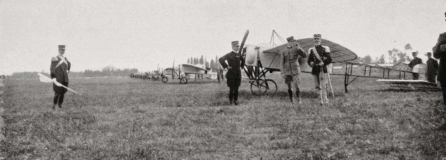 Italian military aviators stand in front of their aircraft as they prepare to receive honors for their service in the Italo-Turkish War. This photograph was taken after their return from combat, at the airfield of Mirafiori, near Turin, in June 1913. <em>Getty Images</em>