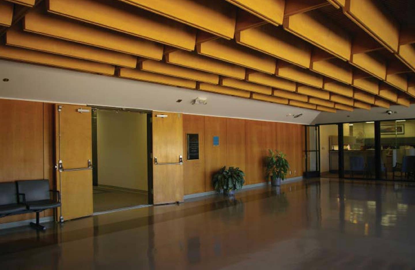 The original main lobby on the fourth floor. This space features original wood wall paneling and a decorative wood ceiling finish. <em>GSA</em>