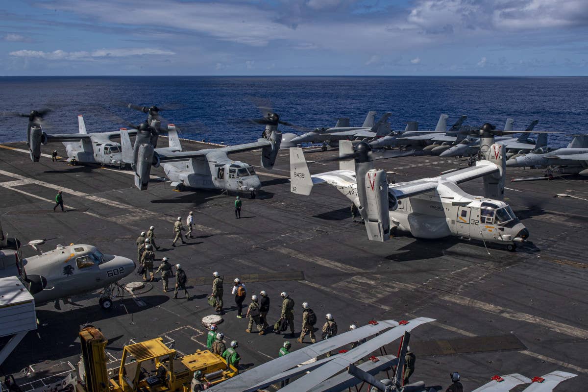A Navy CMV-22B, at right, along with a pair of Marine MV-22Bs, onboard the aircraft carrier USS <em>Carl Vinson</em>. USN