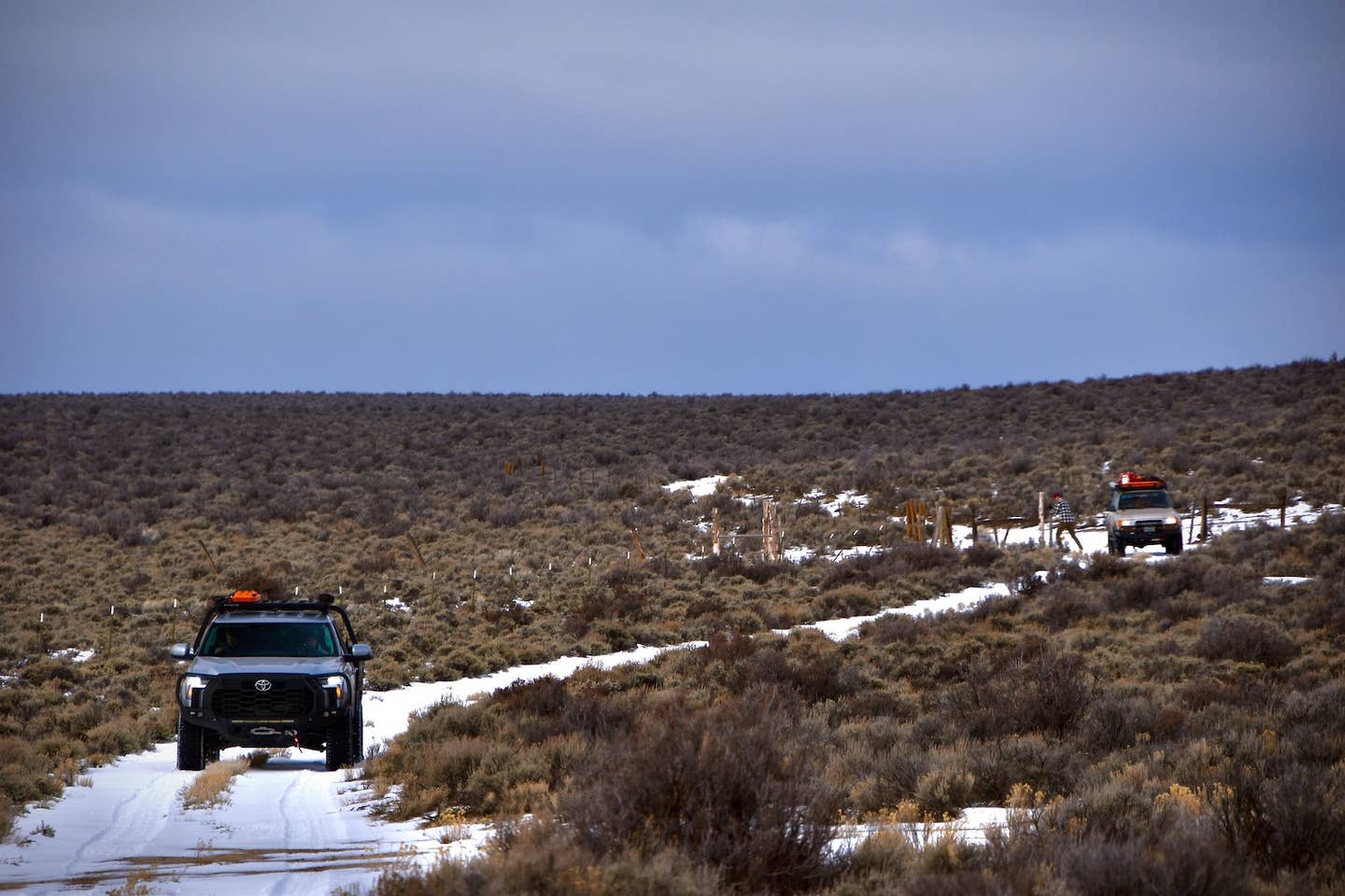 A Toyota Tundra leads a Land Cruiser (80-series) down a snowy trail