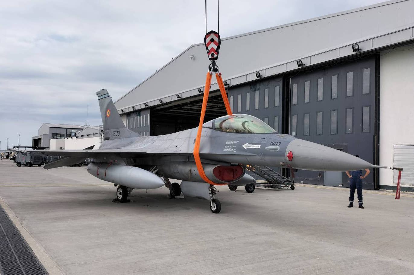 U.S. airmen from the 31st Maintenance Group and maintainers from the Romanian Air Force move an F-16AM at the 86th Air Base in Borcea, Romania, in May 2022. <em>via U.S. Air Force</em>